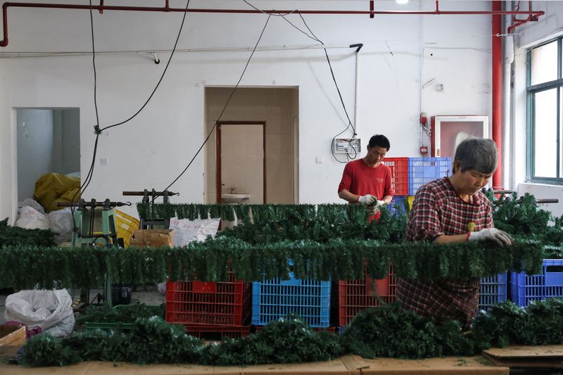Employees work to produce artificial Christmas trees at a factory in Shaoxing, Zhejiang province, China, April 9.