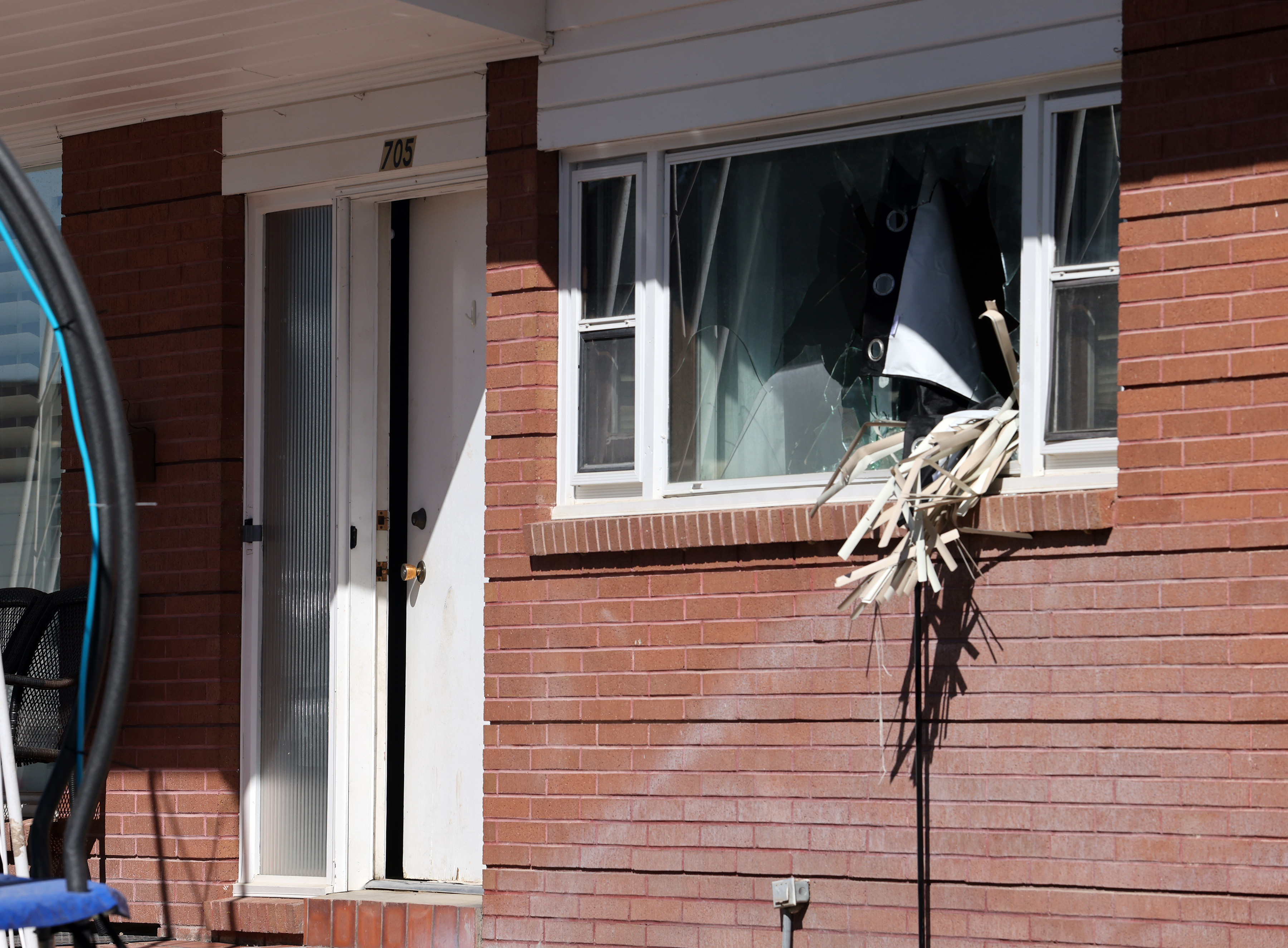 Broken out windows and an open door are seen at a home where three officers and a K-9 were shot Sunday night. The home waits for investigators to begin processing the evidence in Tremonton, Monday.