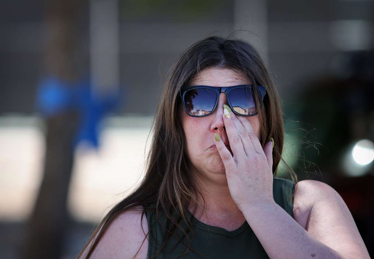 Kristina, who identified herself by her first name only, wipes away tears in front of the Tremonton-Garland Police Department as she talks about two police officers who were shot and killed, in Tremonton, Monday. Kristina is a former colleague of the two officers.