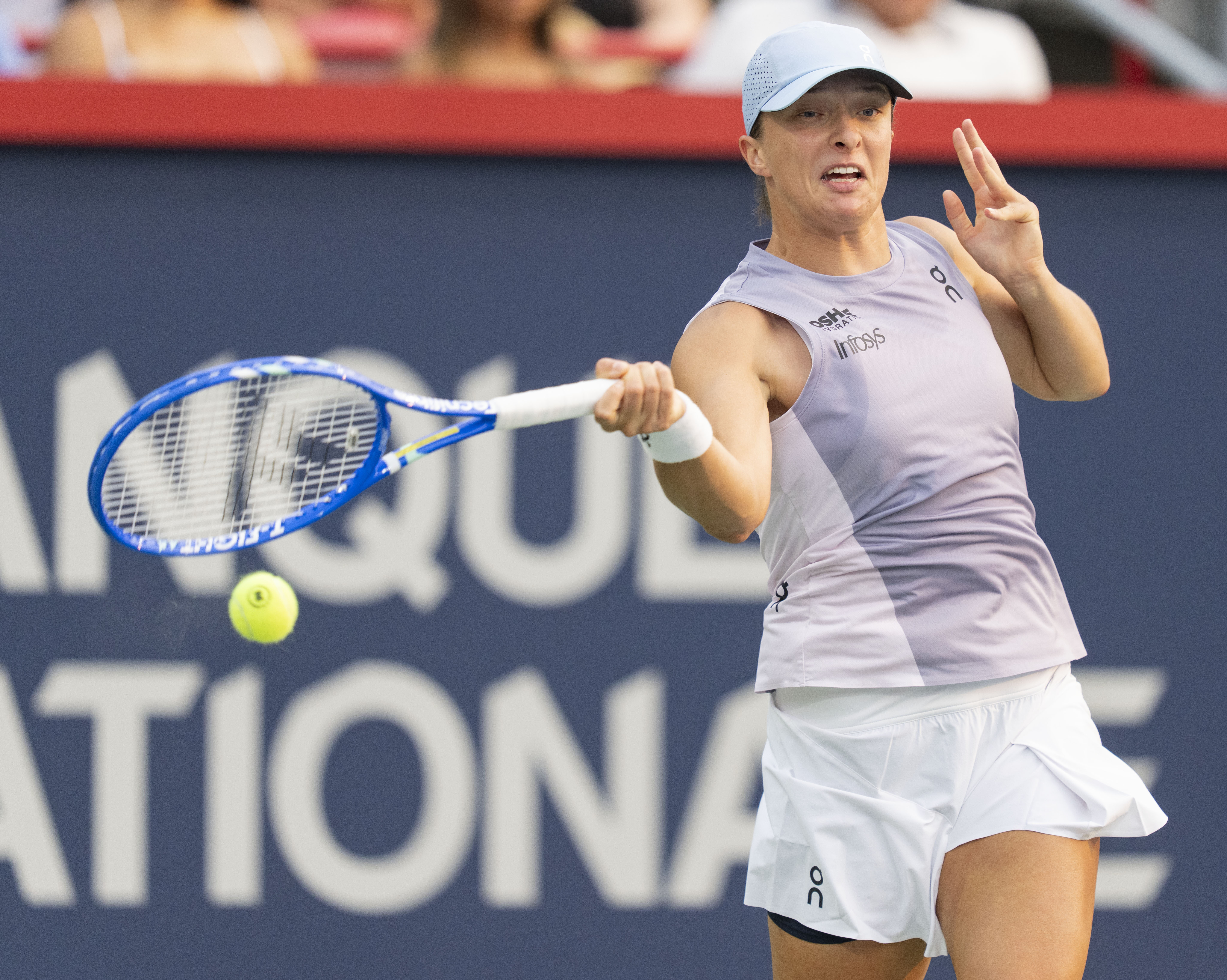 Iga Swiatek, of Poland, hits a return to Clara Tauson, of Denmark, during round of 16 match action at the National Bank Open women's tennis tournament in Montreal, Sunday, Aug. 3, 2025. 