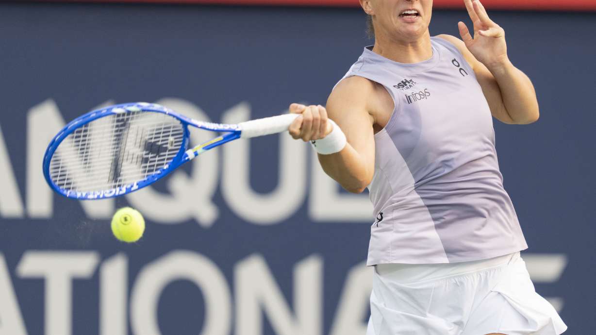 Iga Swiatek, of Poland, hits a return to Clara Tauson, of Denmark, during round of 16 match action at the National Bank Open women's tennis tournament in Montreal, Sunday, Aug. 3, 2025.