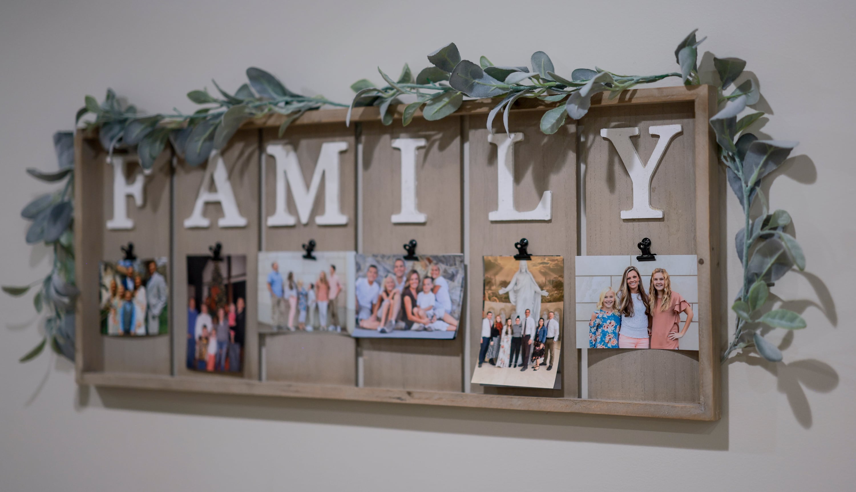A board with family pictures hangs in the hallway of the Olson’s home in Layton on Sunday.