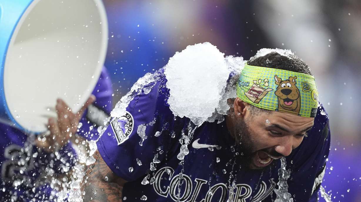 Colorado Rockies' Warming Bernabel, right, is doused by teammate Jordan Beck, back left, after hitting a walk-off RBI single off Los Angeles Dodgers relief pitcher Justin Wrobleski in the ninth inning of a baseball game Monday, Aug. 18, 2025, in Denver.