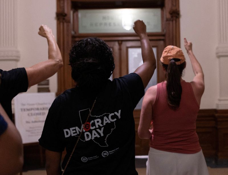 Protesters cheer on Texas state Rep. Nicole Collier after she chose to remain in the Texas House chamber until Wednesday because she did not want to sign the required permission slip that would allow lawmakers to leave the Capitol under escort by Department of Public Safety agents.