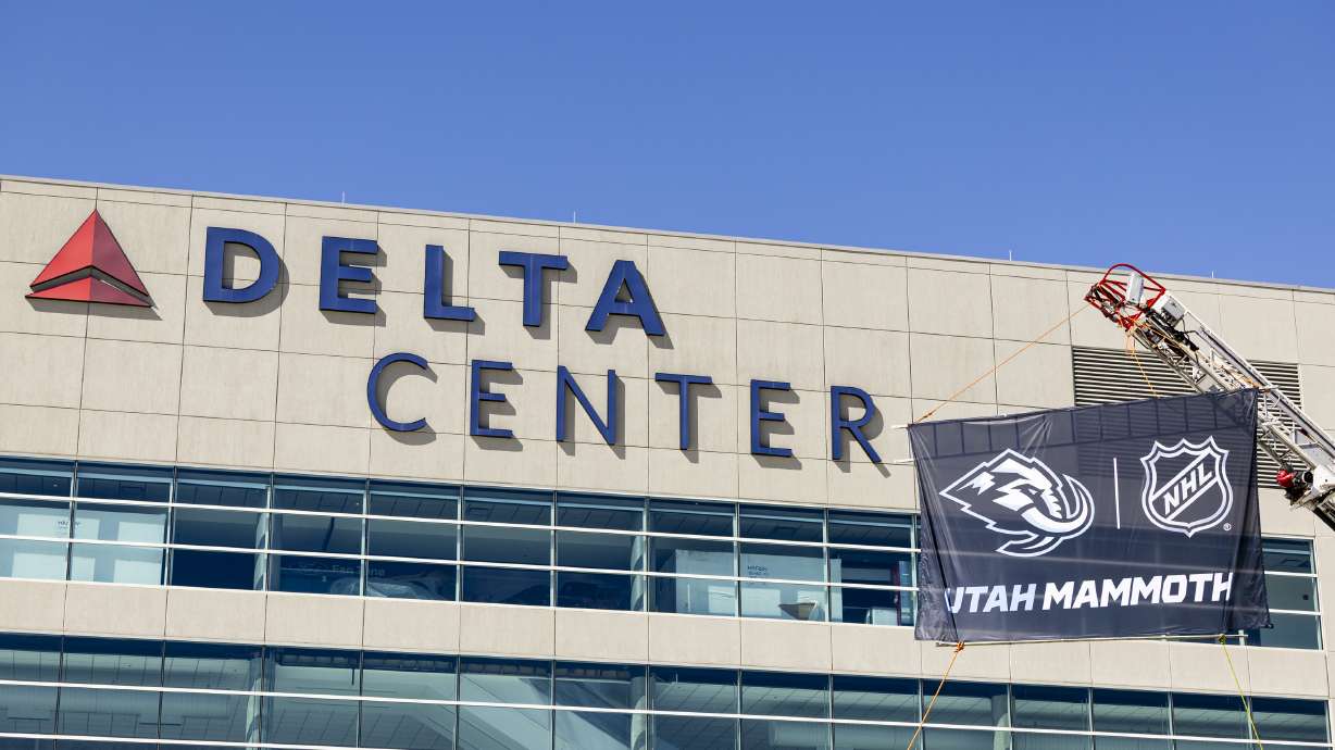Salt Lake City firefighters hoist up new signage before a press conference announcing the Utah Hockey Club is changing their name to Utah Mammoth at the Delta Center in Salt Lake City on Wednesday, May 7, 2025.