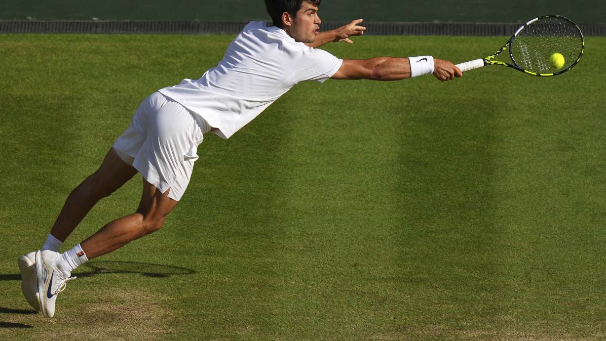 FILE - Carlos Alcaraz, of Spain, returns to Italy's Jannik Sinner in the men's singles final at the Wimbledon Tennis Championships in London, July 13, 2025.