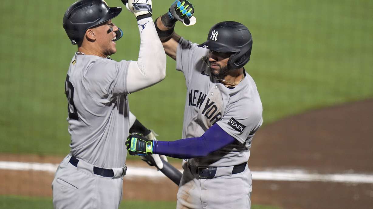 New York Yankees' José Caballero, right, celebrates his home run off Tampa Bay Rays pitcher Mason Montgomery with Aaron Judge during the ninth inning of a baseball game Wednesday, Aug. 20, 2025, in Tampa, Fla.