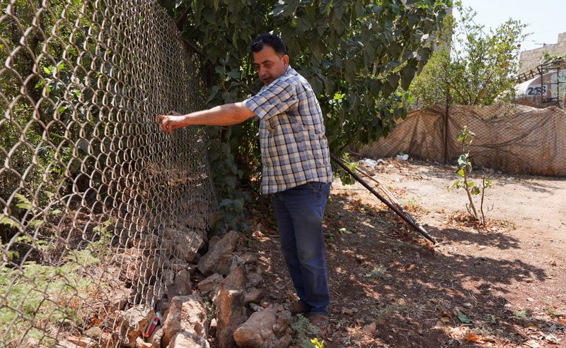 Abdelqader al-Sheikh, a neighbor who lives near the building where, according to Syrian security forces and residents, U.S. forces took part in a predawn raid that targeted a member of the Islamic State group, a U.S. official and a Syrian security source said, attends an interview with Reuters, in Atmeh, Syria, Wednesday. 