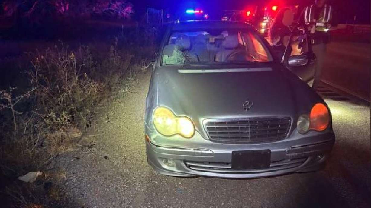 A Utah Highway Patrol trooper and other responders work at the scene where a pedestrian was reportedly struck by a Mercedes car on I-15 in Washington County, Saturday.