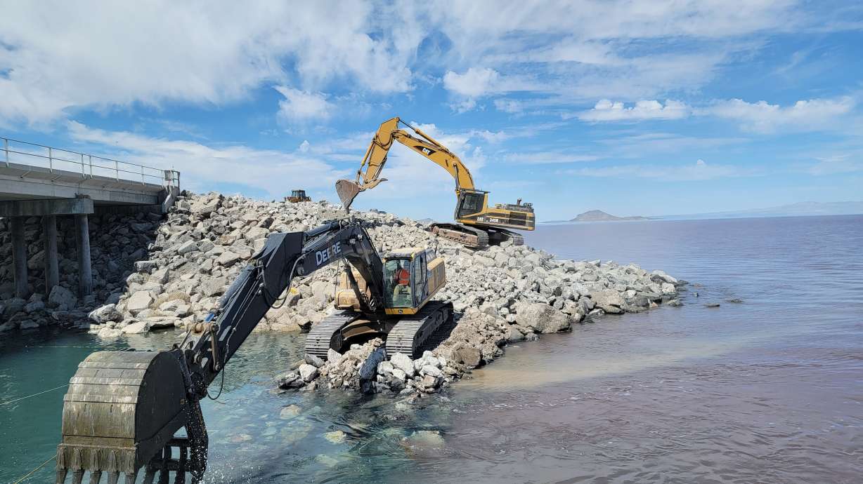 Crews use an excavator to move stones at the Great Salt Lake Causeway to raise the berm by 4 feet in July 2022. A Utah legislature interim committee on Wednesday voted to support draft legislation centered around the berm.