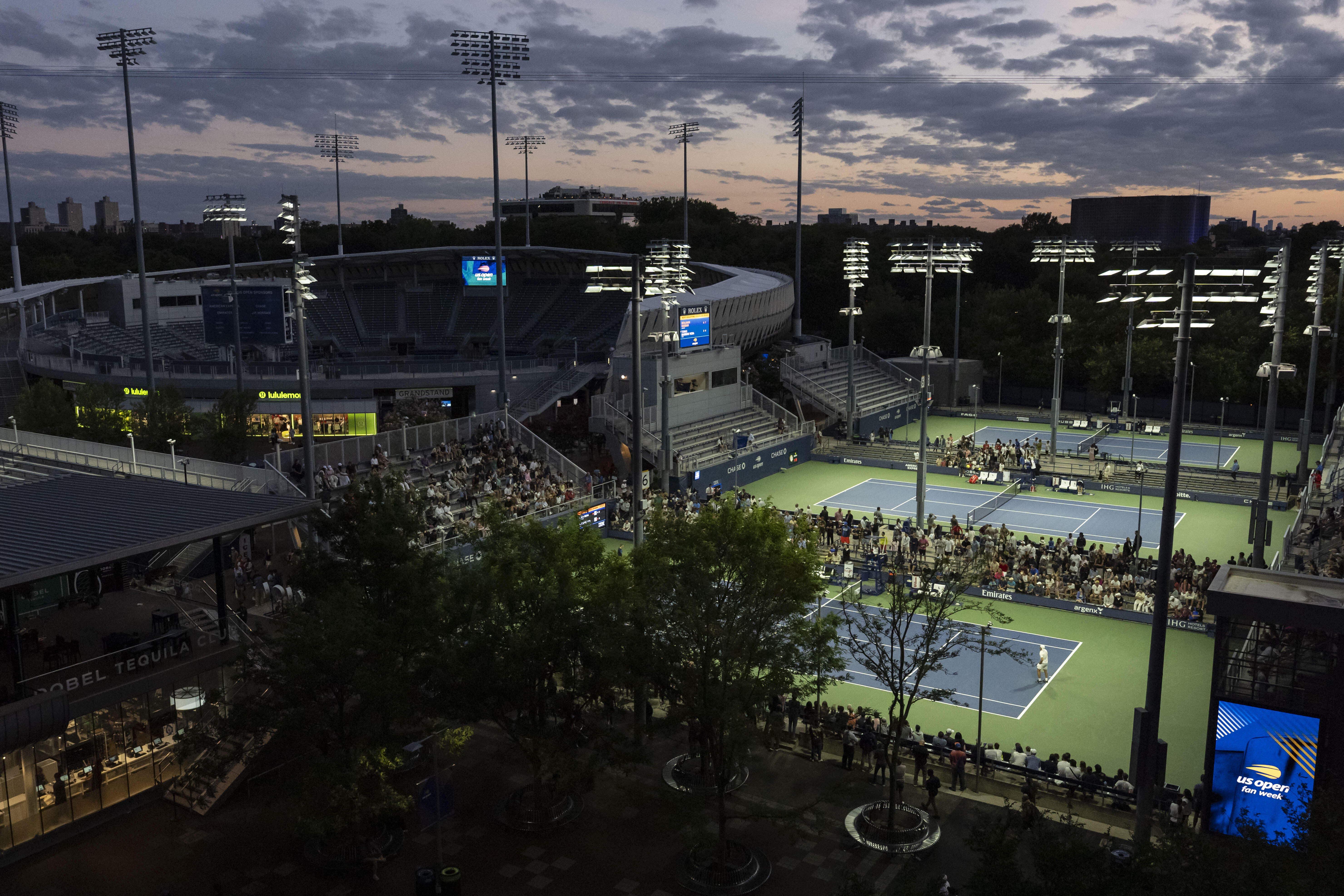 Shielded LED lights shine over the tennis courts during the U.S. Open tennis championships at the USTA Billie Jean King National Tennis Center, Tuesday, Aug. 19, 2025, in New York.