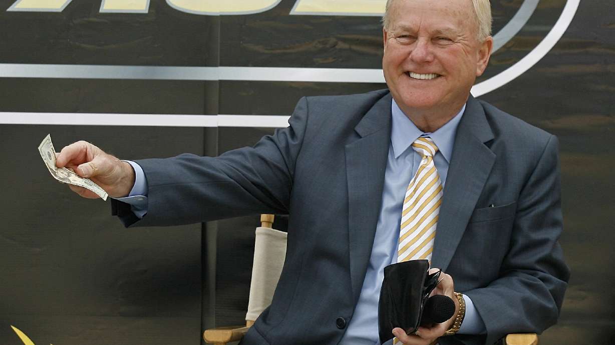 FILE - H.A. "Humpy" Wheeler, president and general manager of Lowe's Motor Speedway, pays up for being late to the news conference to announce the burnout contest that will be held during the pre-race show before the start of the NASCAR Sprint All-Star Race during a new conference at Lowe's Motor Speedway on April 22, in Concord, N.C.