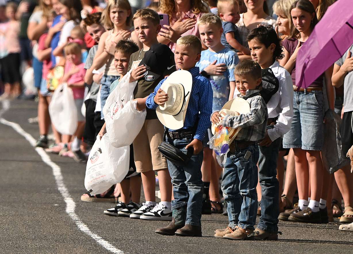 Residents stand in silence as the honor riders pass as thousands gather in Tremonton for the Box Elder Fair Parade Wednesday. They also honored the memory of Sgt. Lee Sorensen and officer Eric Estrada, who were killed in the line of duty.