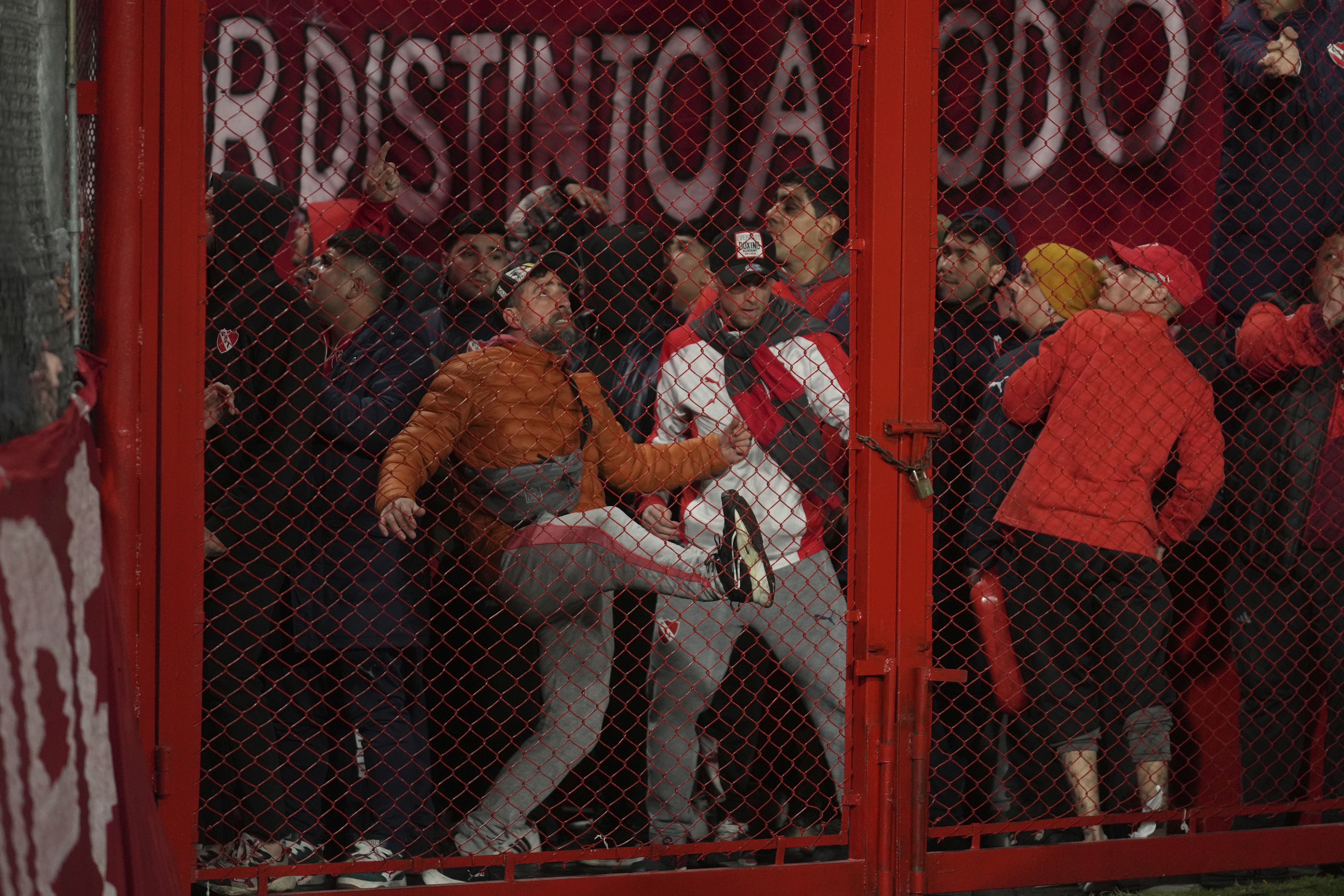 Fans of Argentina's Independiente bang on a barrier during a Copa Sudamericana round of sixteen second leg soccer match against Universidad de Chile at the Libertadores de America stadium in Avellaneda, Argentina, Wednesday, Aug. 20, 2025.