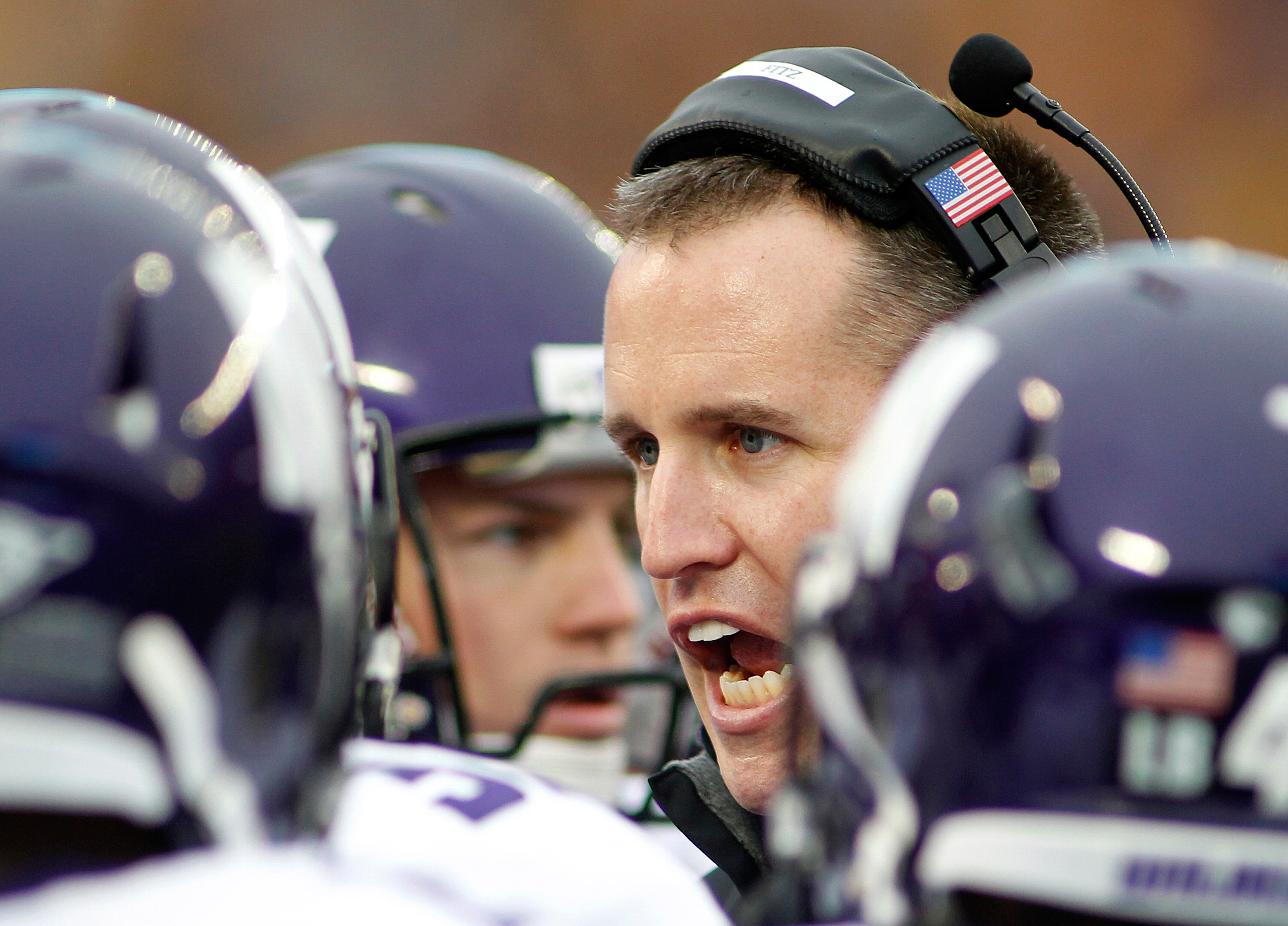 FILE - Northwestern head coach Pat Fitzpatrick talks to his players in the first half of a NCAA college football game against Minnesota in Minneapolis, Oct. 13, 2012. 