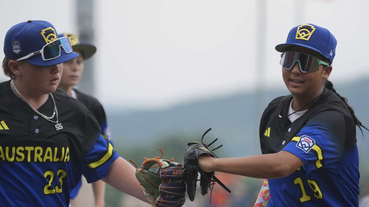 Australia's Monica Arcuri, right, and Braxton Black, left, run off the field during the fourth inning of a baseball game at the Little League World Series against Canada, Sunday, Aug. 17, 2025, in South Williamsport, Pa.