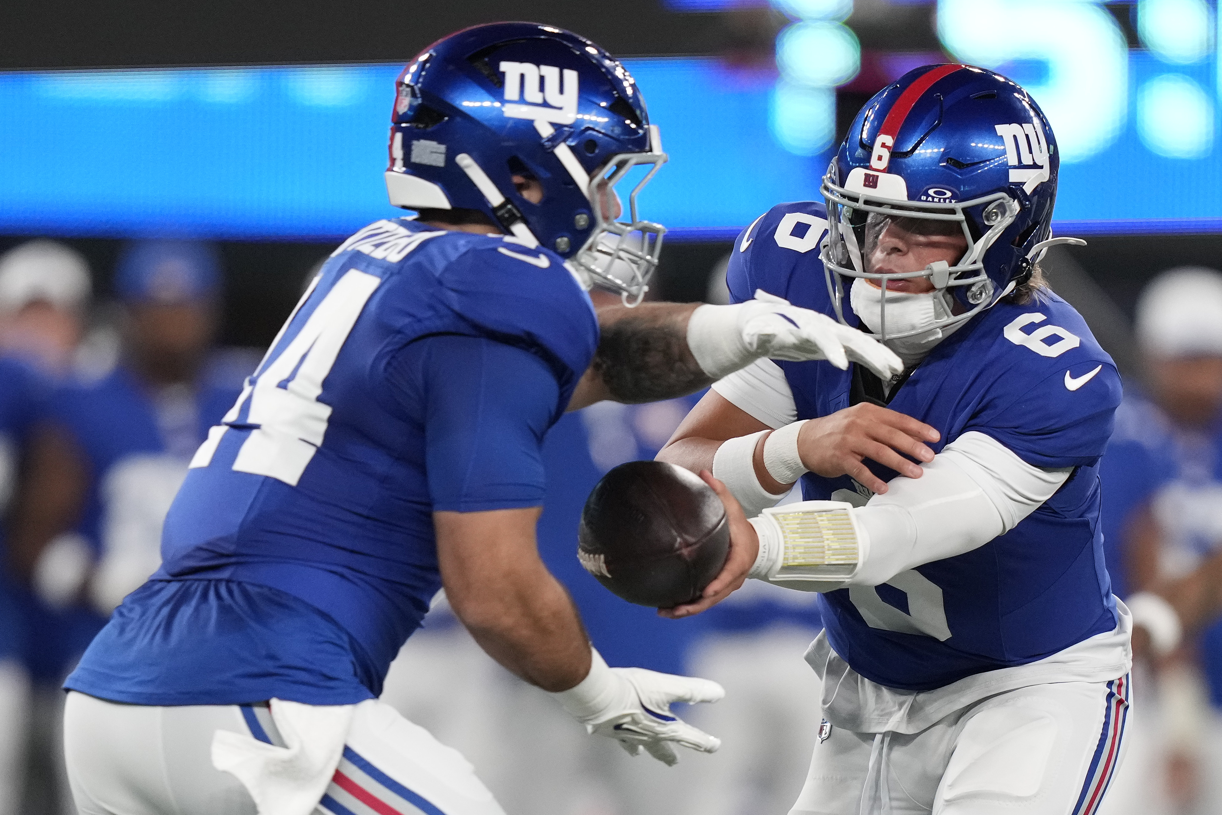 New York Giants quarterback Jaxson Dart (6) hands off the ball to running back Cam Skattebo (44) during the first quarter of an NFL football game, Thursday, Aug. 21, 2025, in East Rutherford, N.J.