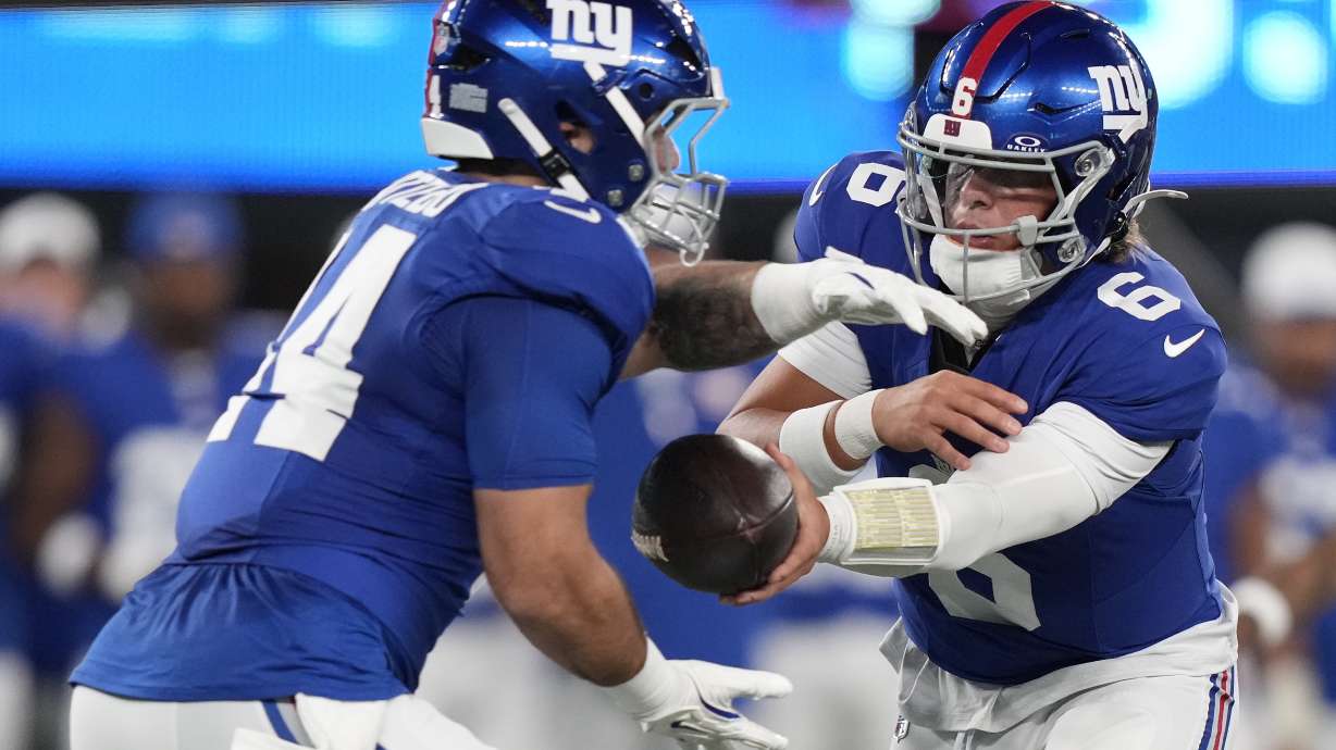 New York Giants quarterback Jaxson Dart (6) hands off the ball to running back Cam Skattebo (44) during the first quarter of an NFL football game, Thursday, Aug. 21, 2025, in East Rutherford, N.J.