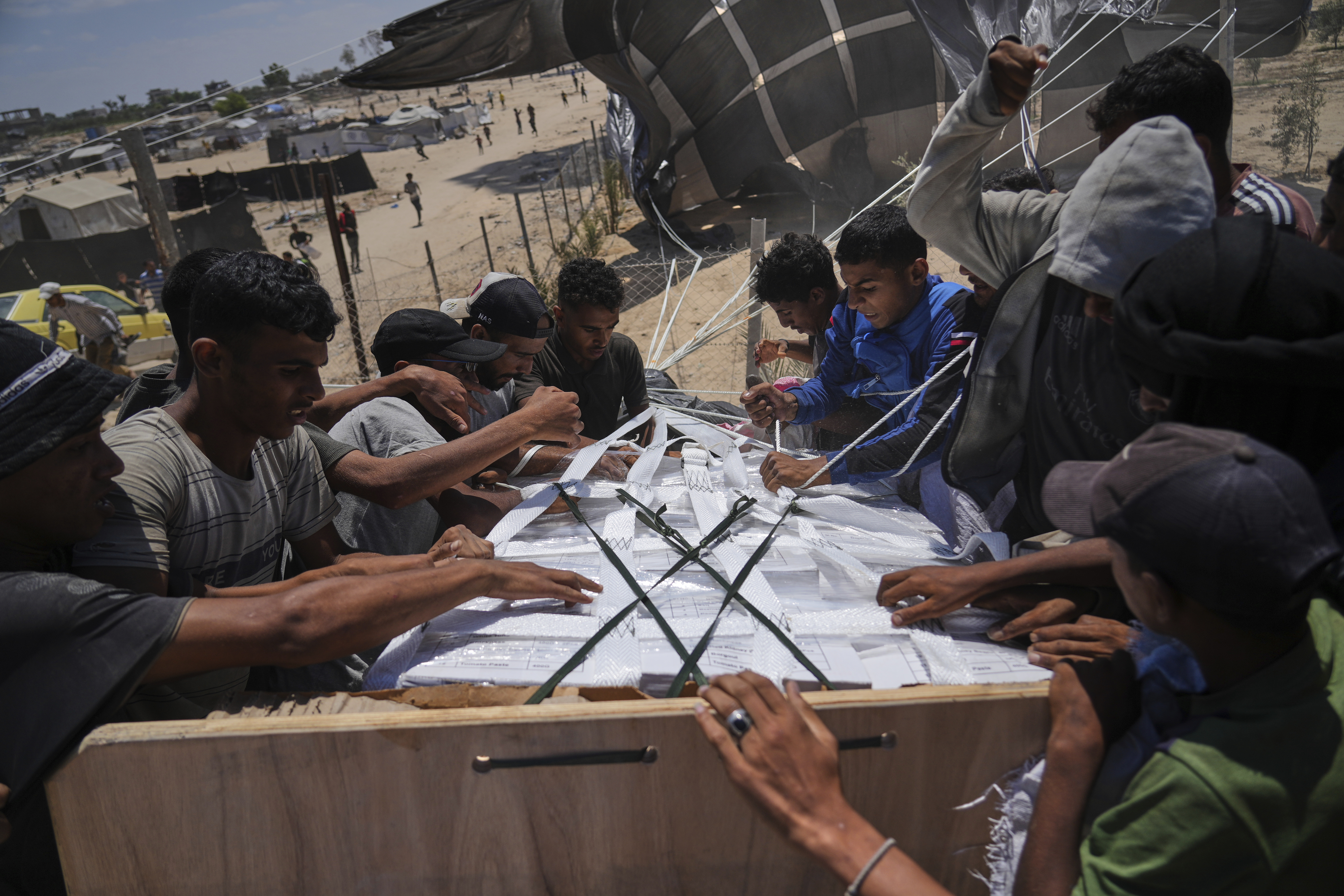 Palestinians open humanitarian aid packages that were airdropped into Deir al-Balah in central Gaza on Aug. 5.