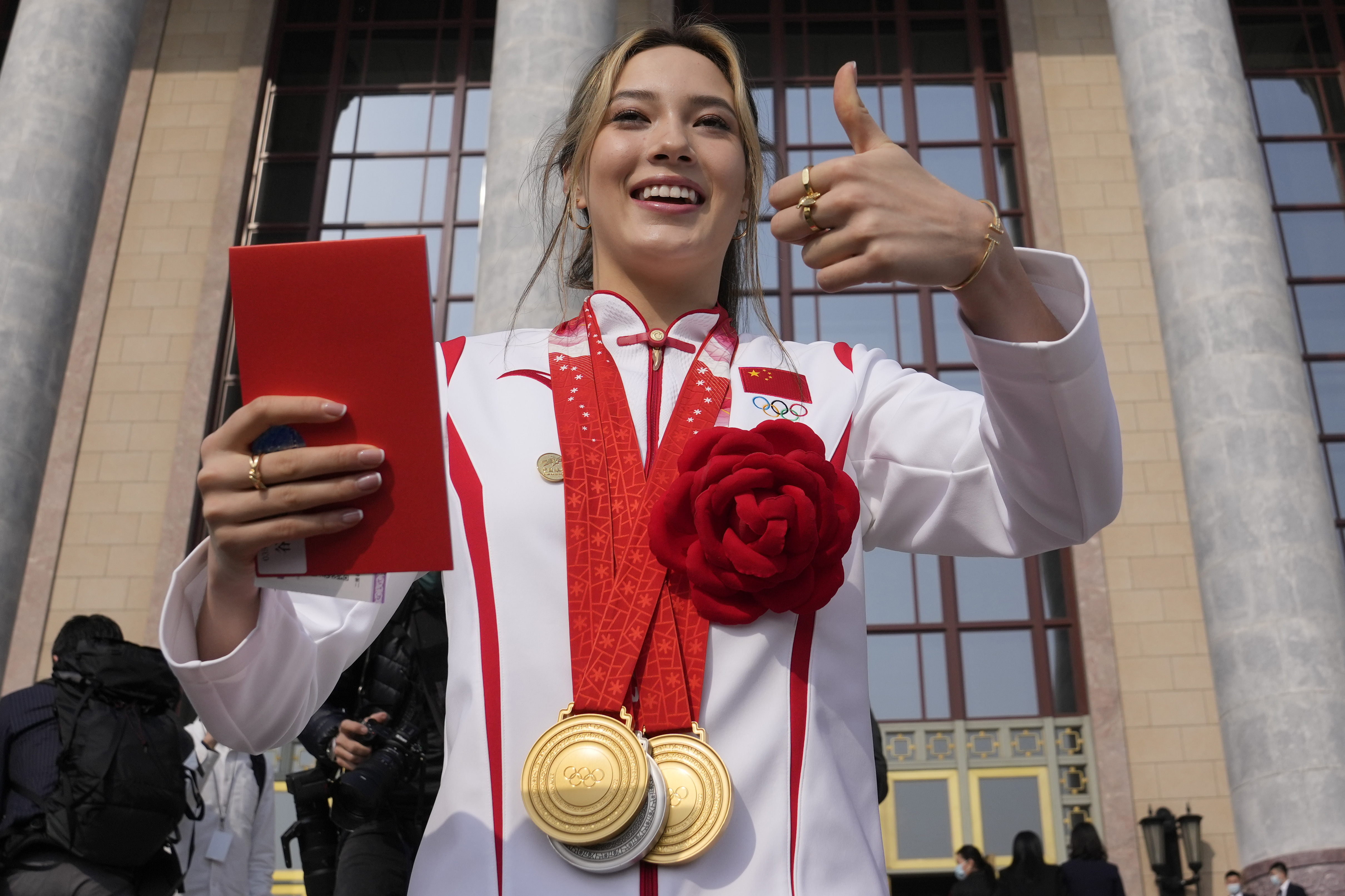 FILE - Olympic gold medalist Eileen Gu poses with her three medals before a commendation ceremony for role models of the Beijing Winter Olympics and Paralympics at the Great Hall of the People, on April 8, 2022, in Beijing.