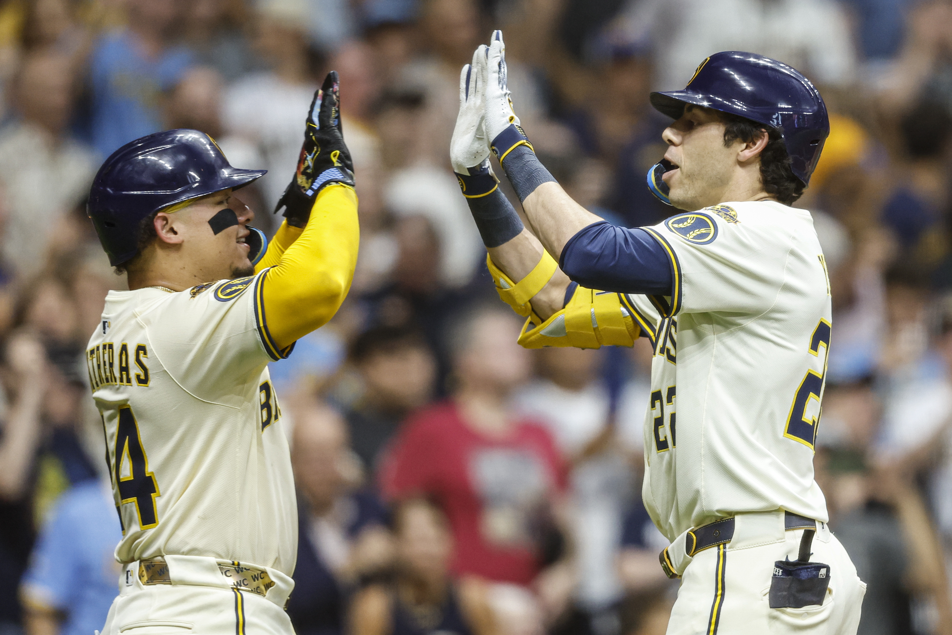 Milwaukee Brewers' Christian Yelich, right, high-fives with William Contreras after Yelich hit a two-run home run against the Pittsburgh Pirates during the fifth inning of a baseball game, Tuesday, Aug.12, 2025, in Milwaukee. 