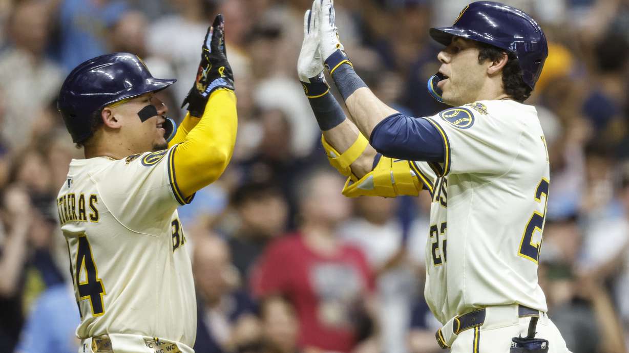 Milwaukee Brewers' Christian Yelich, right, high-fives with William Contreras after Yelich hit a two-run home run against the Pittsburgh Pirates during the fifth inning of a baseball game, Tuesday, Aug.12, 2025, in Milwaukee.