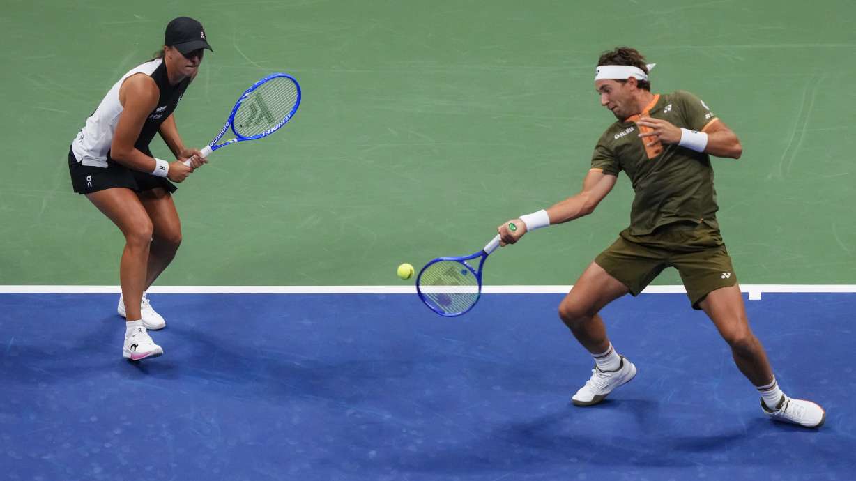 Casper Ruud, right, of Norway, plays with Iga Swiatek, left, of Poland, during the mixed doubles final at the U.S. Open tennis championships, Wednesday, Aug. 20, 2025, in New York.