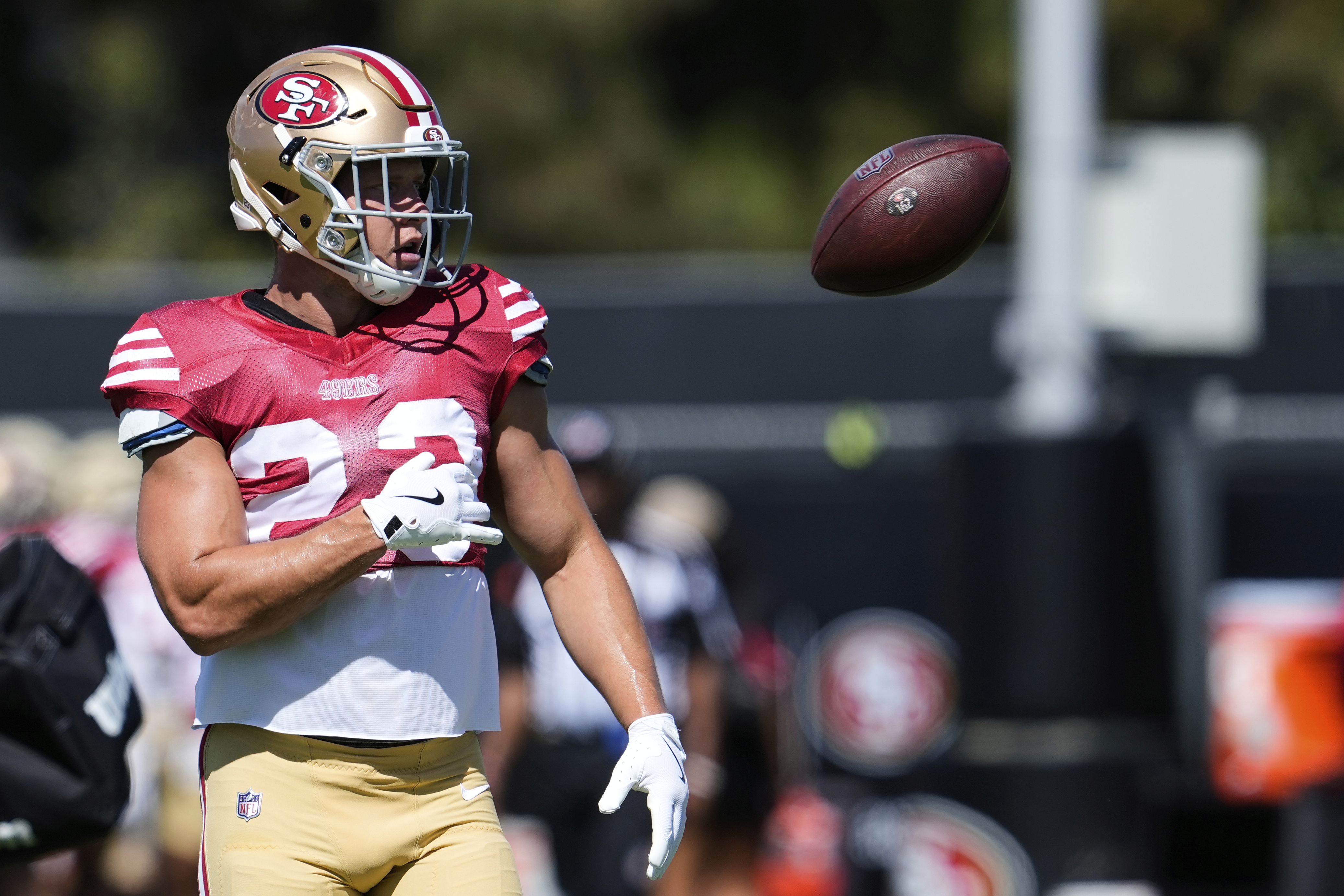 San Francisco 49ers running back Christian McCaffrey tosses the ball during a joint NFL football training camp with the Denver Broncos, Thursday, Aug. 7, 2025, in Santa Clara, Calif.