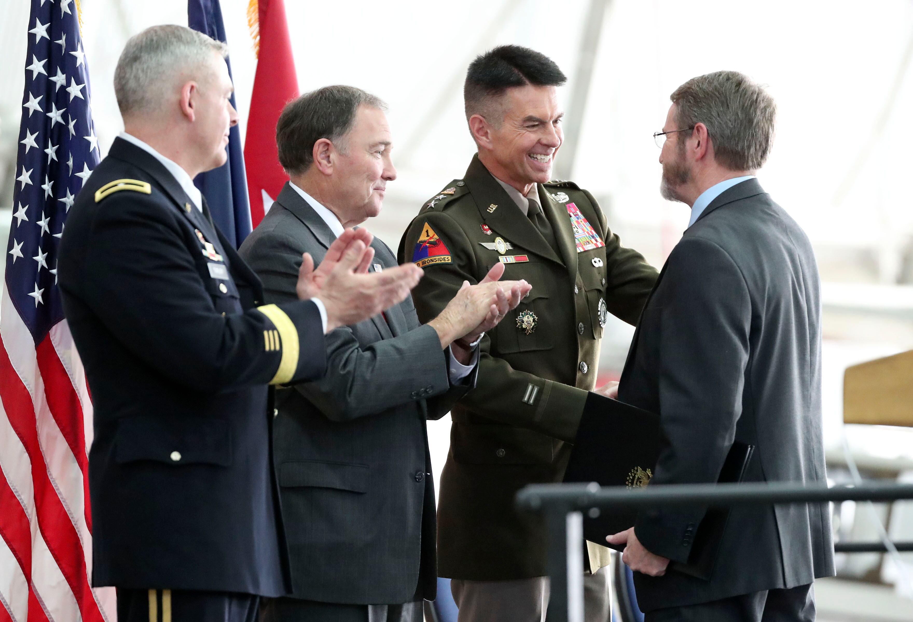Utah National Guard Brig. Gen. Michael Turley, left, and Gov. Gary Herbert watch as Maj. Gen. Jeff Burton, Utah National Guard adjutant general, shakes hands with Barry McLerran, during a retirement ceremony for Burton at the Roland R. Wright Air National Guard Base in Salt Lake City, Nov. 7, 2019.
