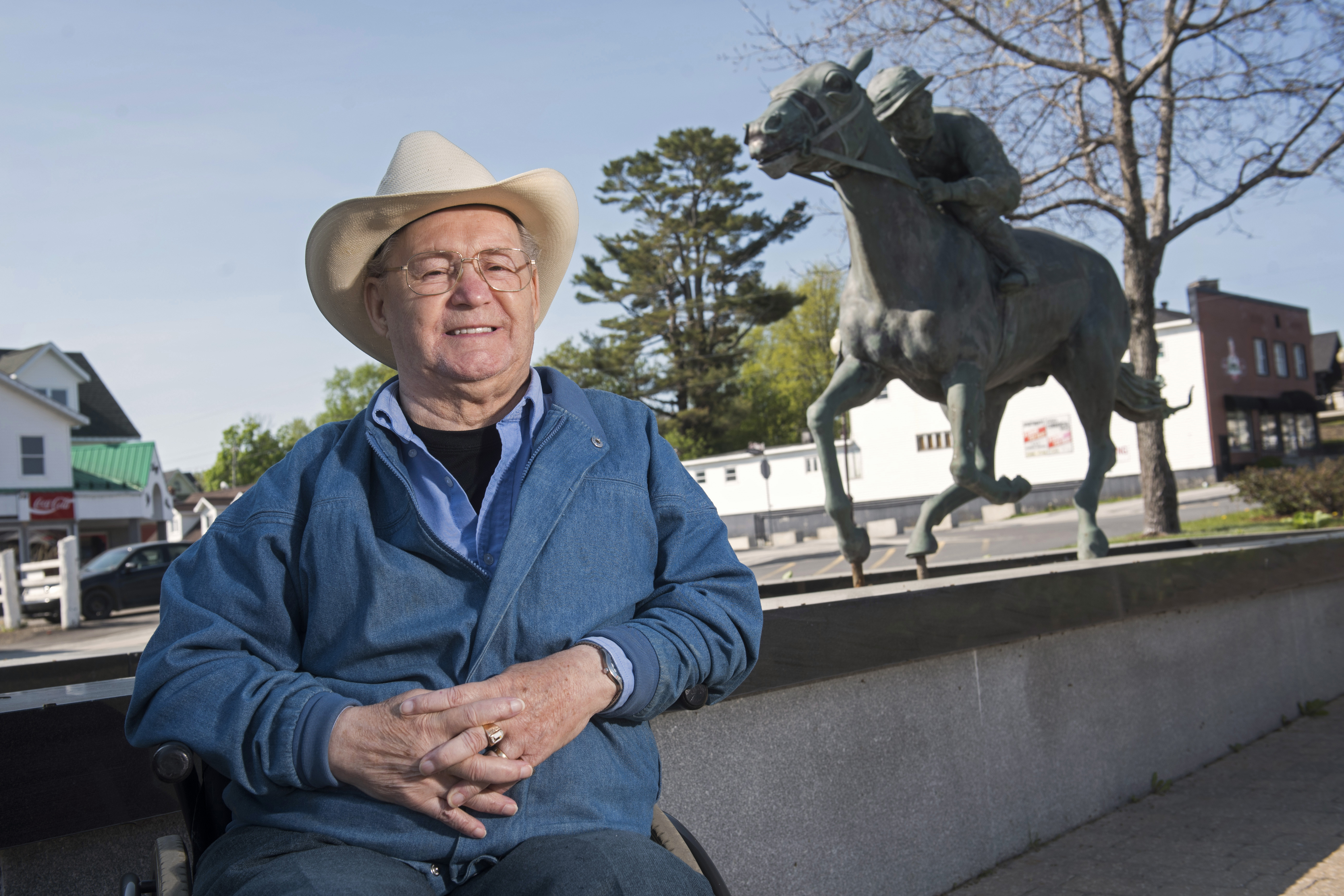 FILE - Ron Turcotte poses next to a statue of him and Secretariat in Grand Falls, New Brunswick, Canada, May 31, 2023. 