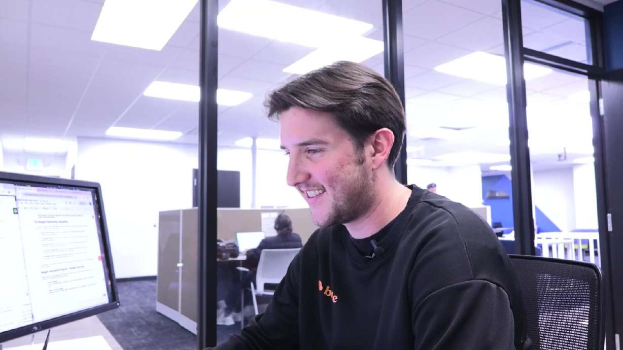 University of Utah senior Drew Gordillo working while wearing a Beagle Technologies shirt. Gordillo is designing and leading an internship program for University of Utah students that allows them to do a work trial at Beagle and potentially be hired there full-time once they graduate.