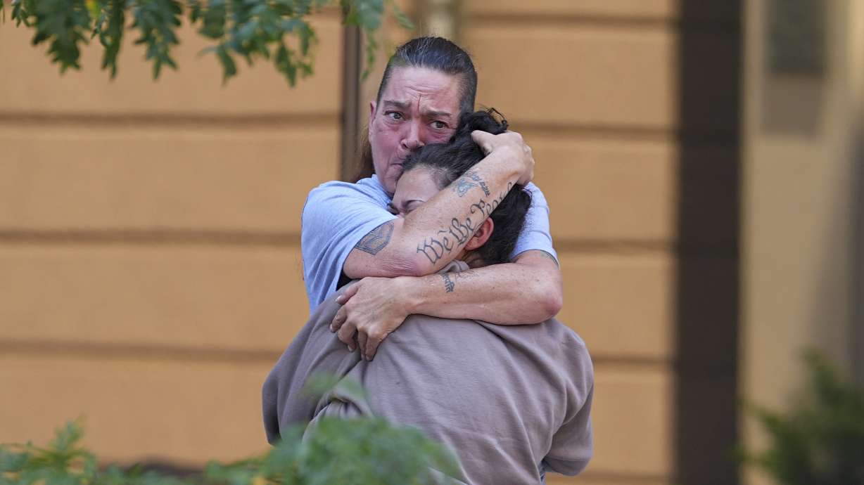 Crystina Page, back, hugs a well-wisher outside the El Paso County Courthouse after a judge ruled against accepting a plea deal in the case of a funeral home owner who stored roughly 189 decomposing bodies in a building Friday, in Colorado Springs, Colo.