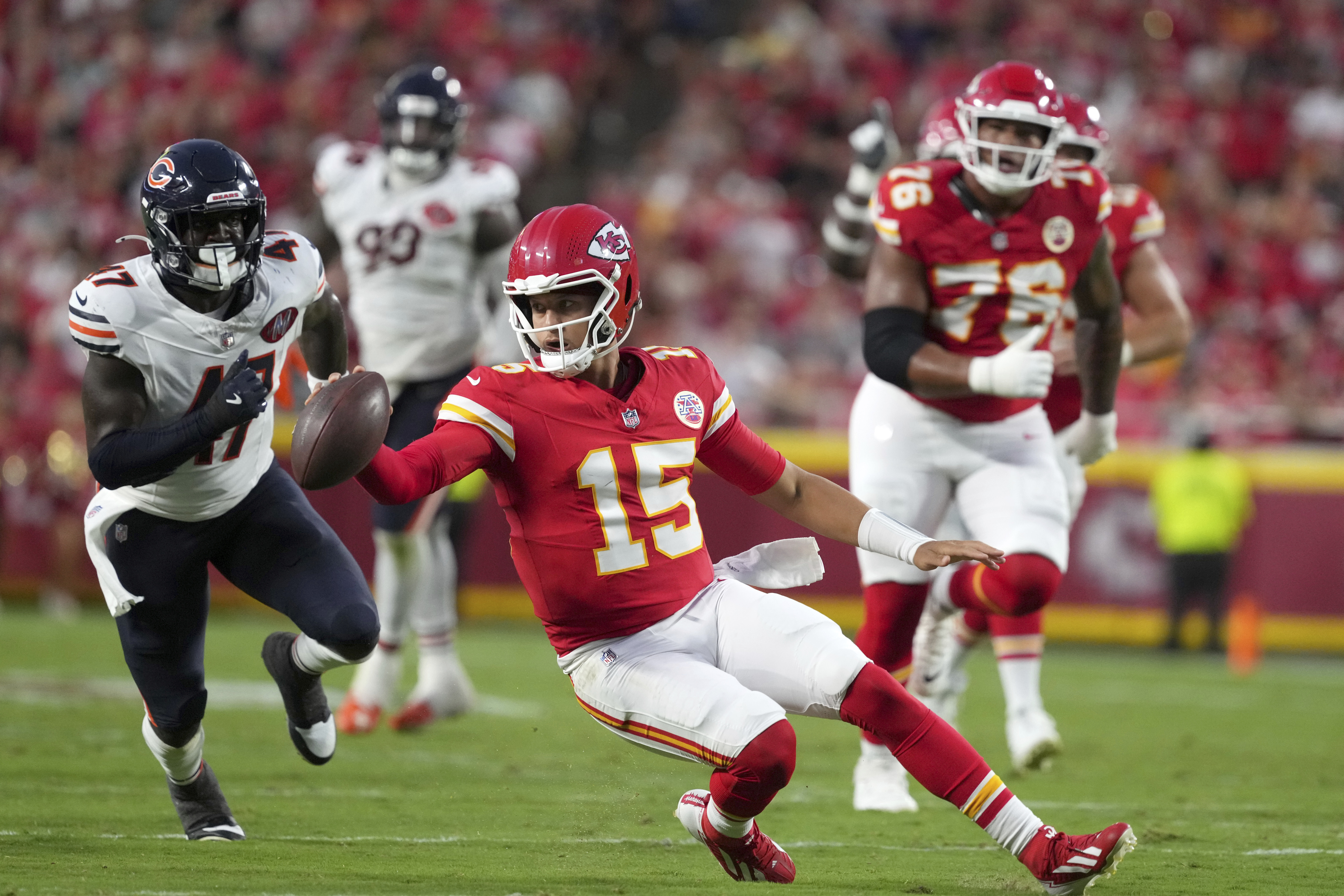 Kansas City Chiefs quarterback Patrick Mahomes (15) scrambles as Chicago Bears linebacker Ruben Hyppolite II (47) defends during the first half of a preseason NFL football game Friday, Aug. 22, 2025, in Kansas City, Mo.