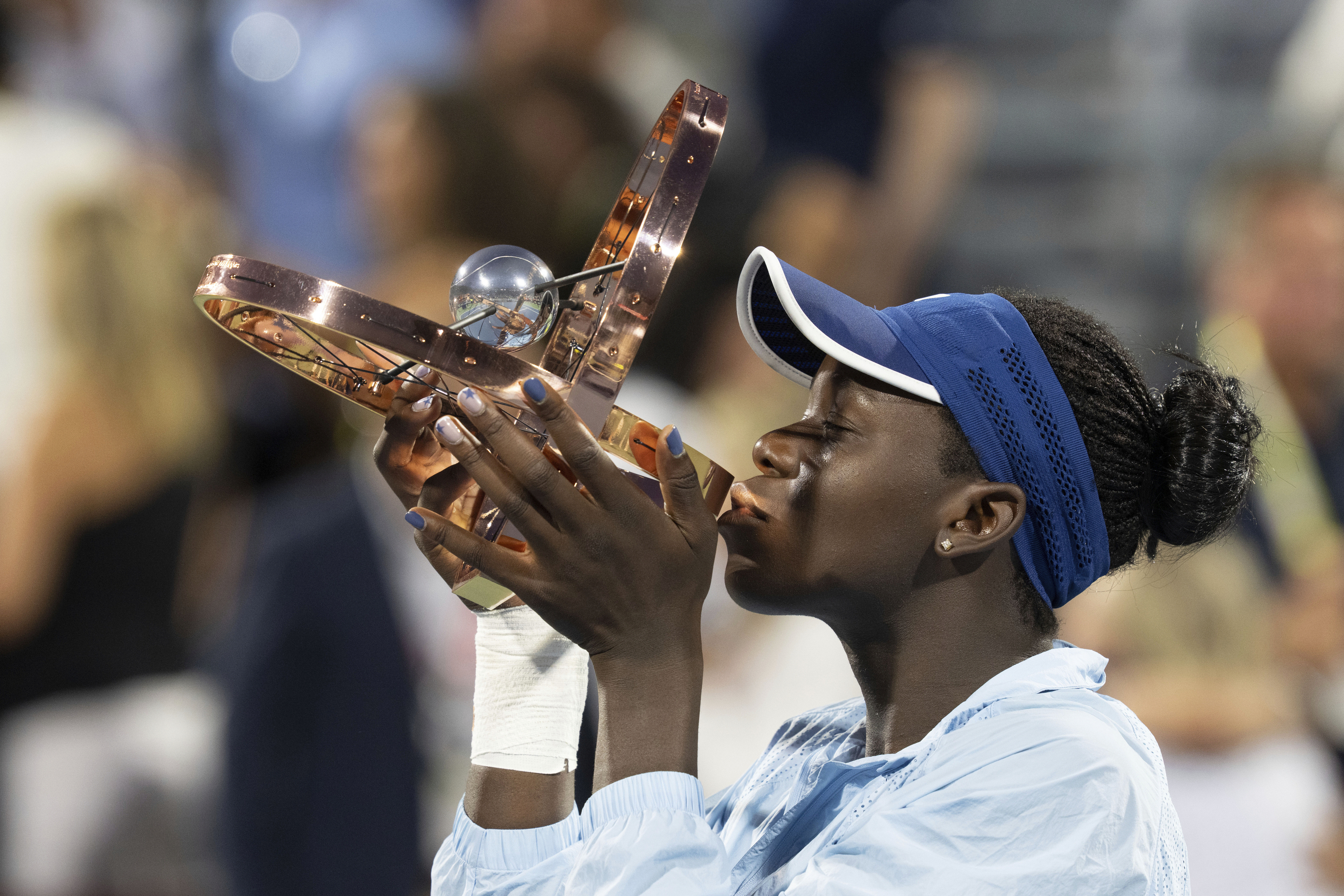 Victoria Mboko of Canada kisses the trophy following her win over Naomi Osaka of Japan during finals tennis action at the National Bank Open in Montreal, Thursday, Aug. 7, 2025.