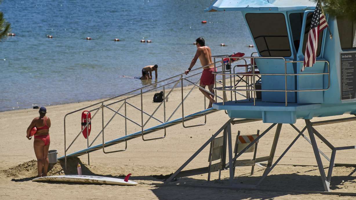Los Angeles County lifeguards stand on guard as people cool off at Castaic Lake on Wednesday in Castaic, Calif.