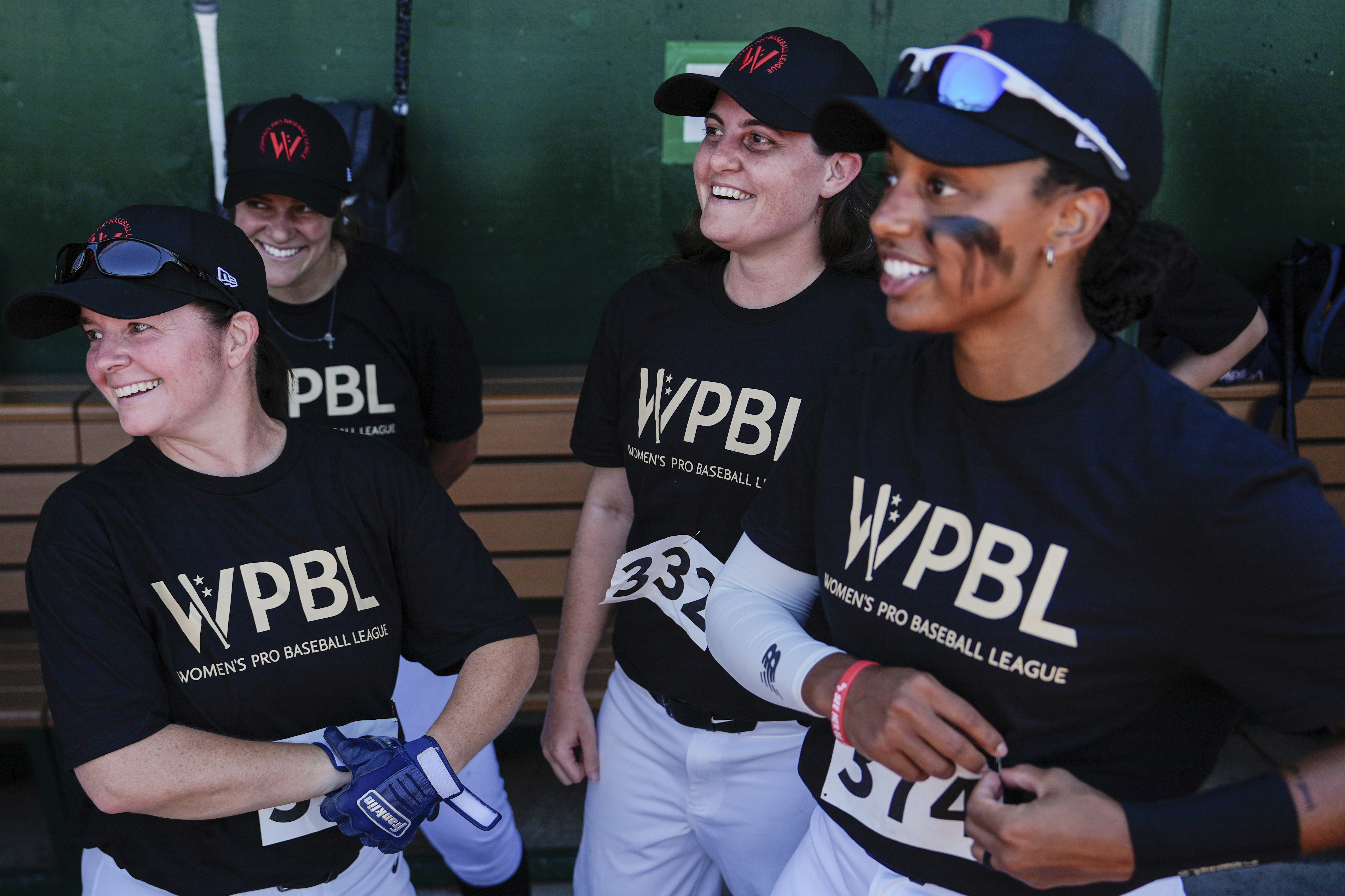 Lauren Boden, second from right, Stephanie Everett, right, and other players talk in the dugout during the first day of tryouts for the Women's Professional Baseball League, Friday, Aug 22, 2025, at the Washington Nationals Youth Baseball Academy in Washington.
