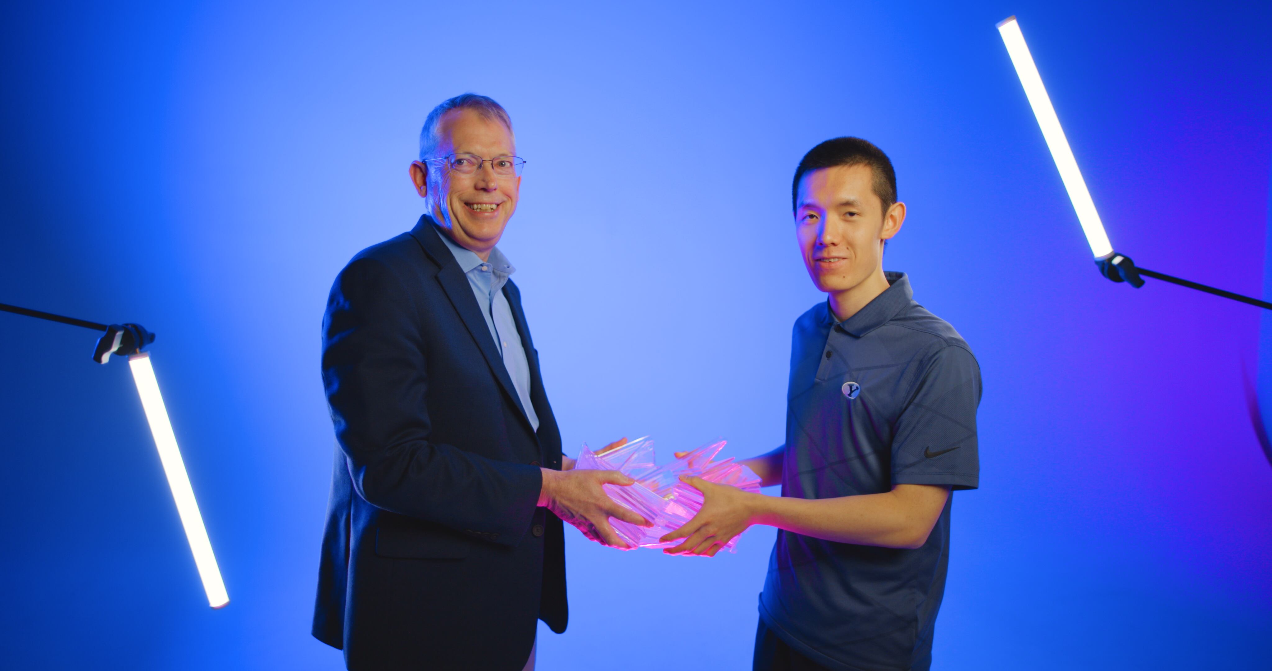 Brigham Young University student Kelvin (Zhongyuan) Wang, right, and BYU professor Larry Howell pose together while holding a new flower-bloom origami pattern Wang discovered.