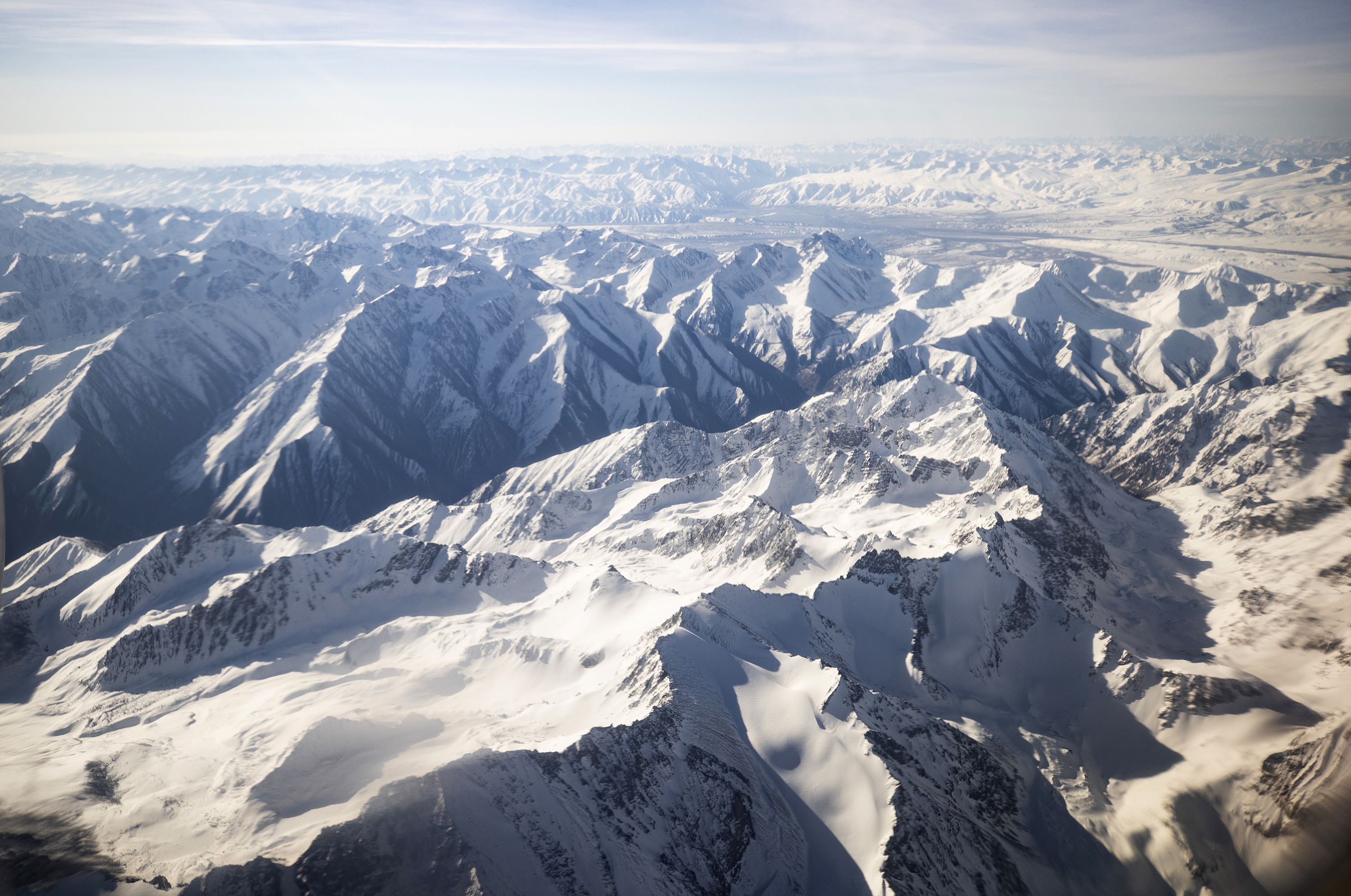 An aerial view taken from a commercial plane shows Tian Shan Range in Kyrgyzstan on April 29, 2021. Hopes are fading that an injured climber who has been stuck on a mountain in Kyrgyzstan for 12 days after rescue efforts had to be terminated because of bad weather.