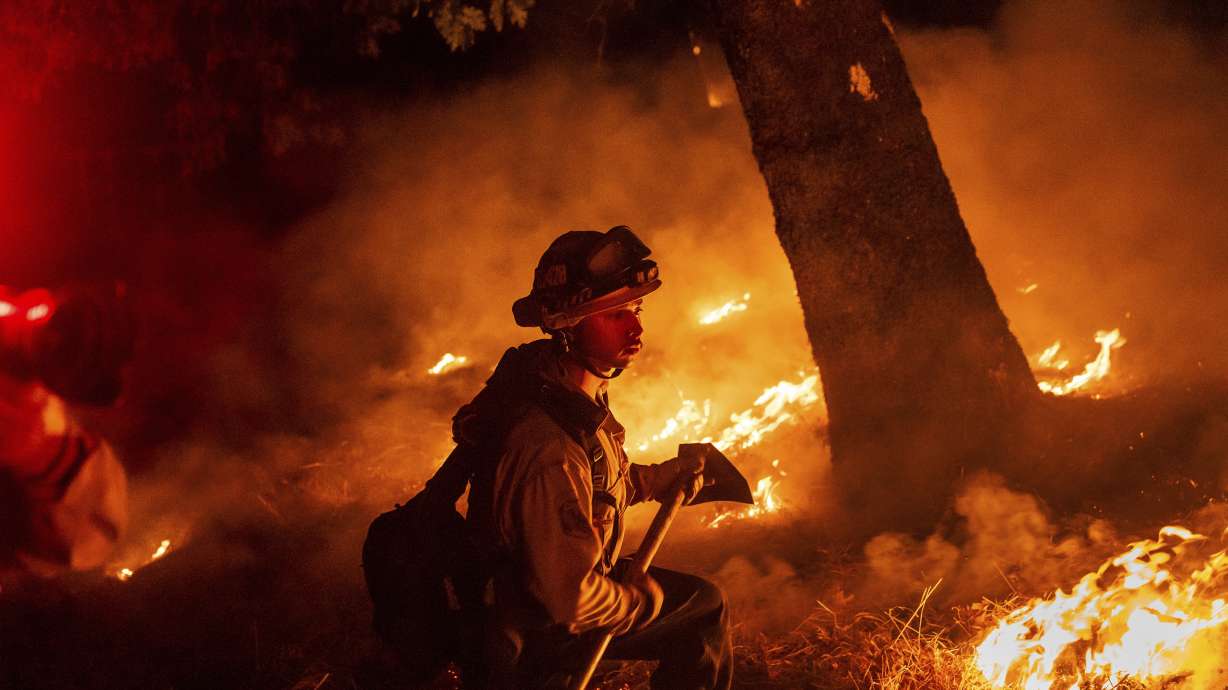 A firefighter battles the Pickett Fire burning in the Aetna Springs area of Napa County, Calif., on Saturday.