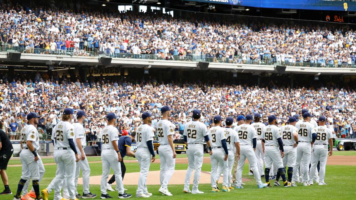 Milwaukee Brewers players walk onto the field for the ceremonial first pitch during the Bob Uecker Celebration of Life before a baseball game against the San Francisco Giants, Sunday, Aug. 24, 2025, in Milwaukee.