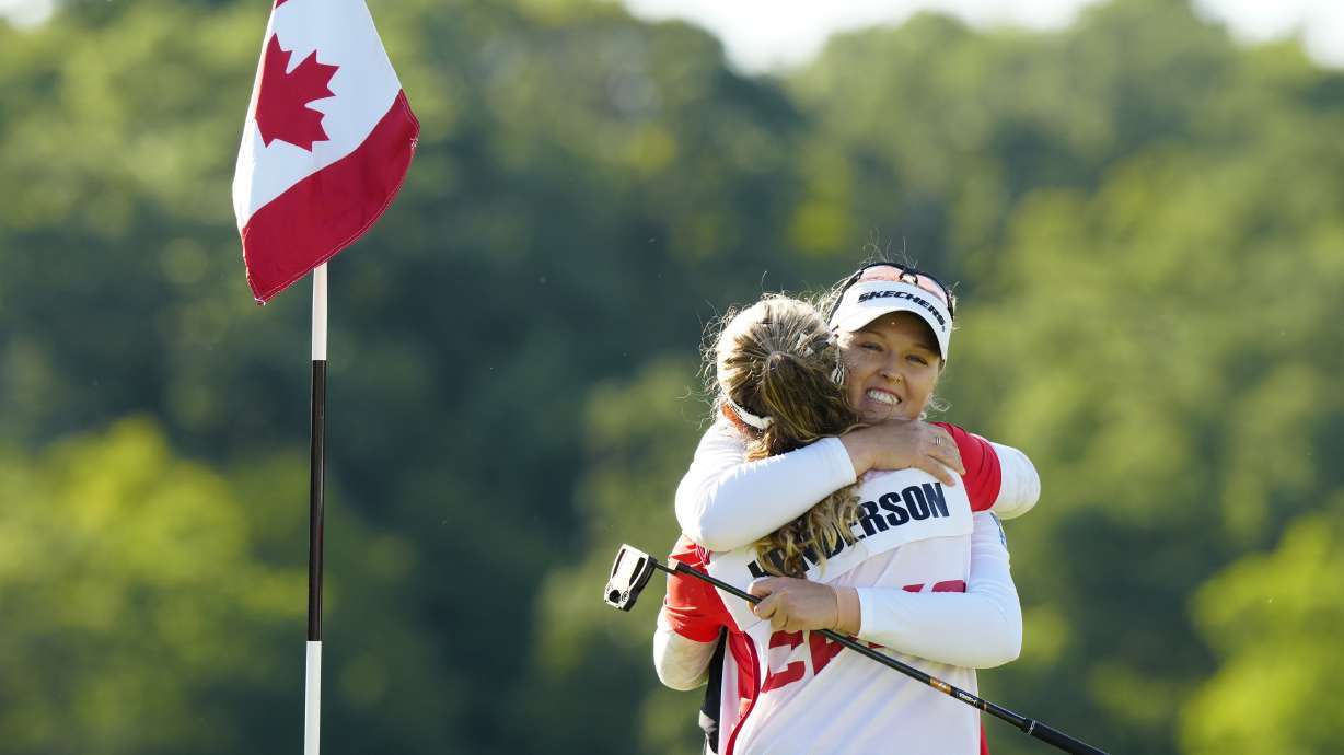 Brooke Henderson, right, of Canada, hugs her caddie, and sister, Brittany Henderson, left, after winning the Canadian Women's Open golf tourrnament on the 18th hole in Mississauga, Ontario, Sunday Aug. 24, 2025.