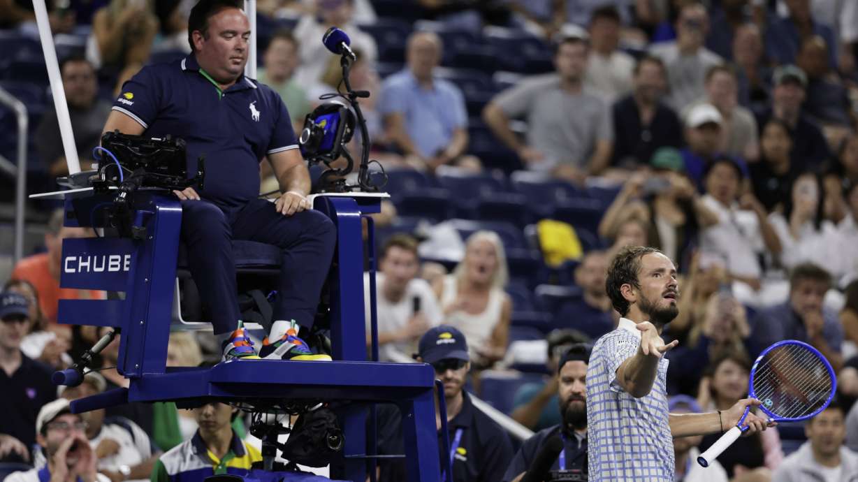 Daniil Medvedev, of Russia, bottom right, reacts next to chair umpire, Greg Allensworth, left, after a photographer ran onto the court during a match against Benjamin Bonzi, of France, in the first-round of the U.S. Open tennis championships, Sunday, Aug. 24, 2025, in New York.