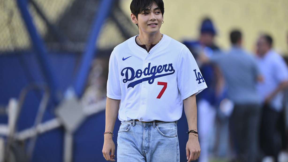 V, a member of the South Korean K-pop band BTS, looks on during batting practice before a baseball game between the Los Angeles Dodgers and the Cincinnati Reds Monday, Aug. 25, 2025, in Los Angeles.