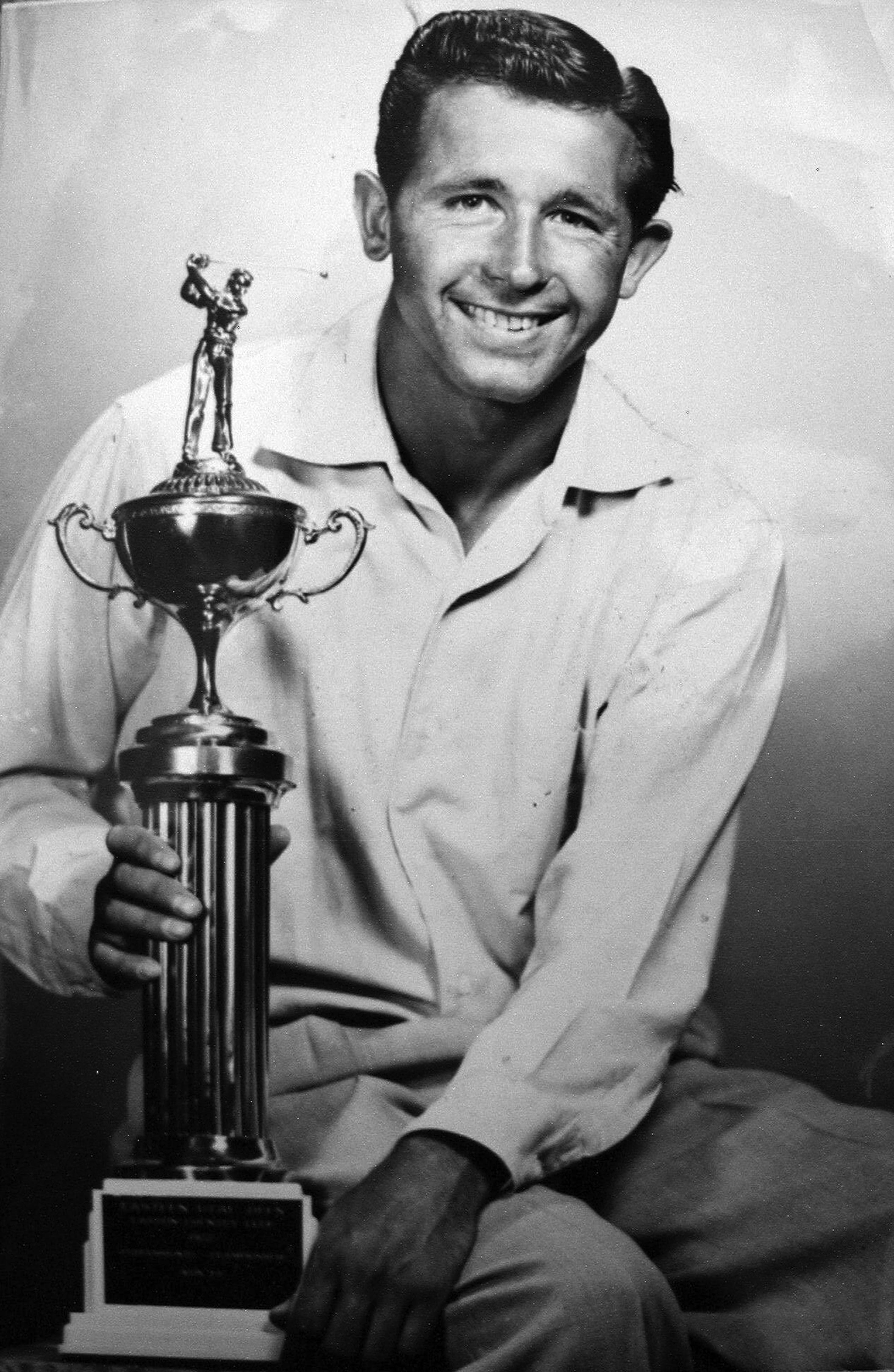 Ernie Schneiter Jr. is pictured in this 1957 photograph with one of many trophies he won over his long golf career. Schneiter won his first Utah Junior Open in 1945, leading him to fall in love with the game of golf.