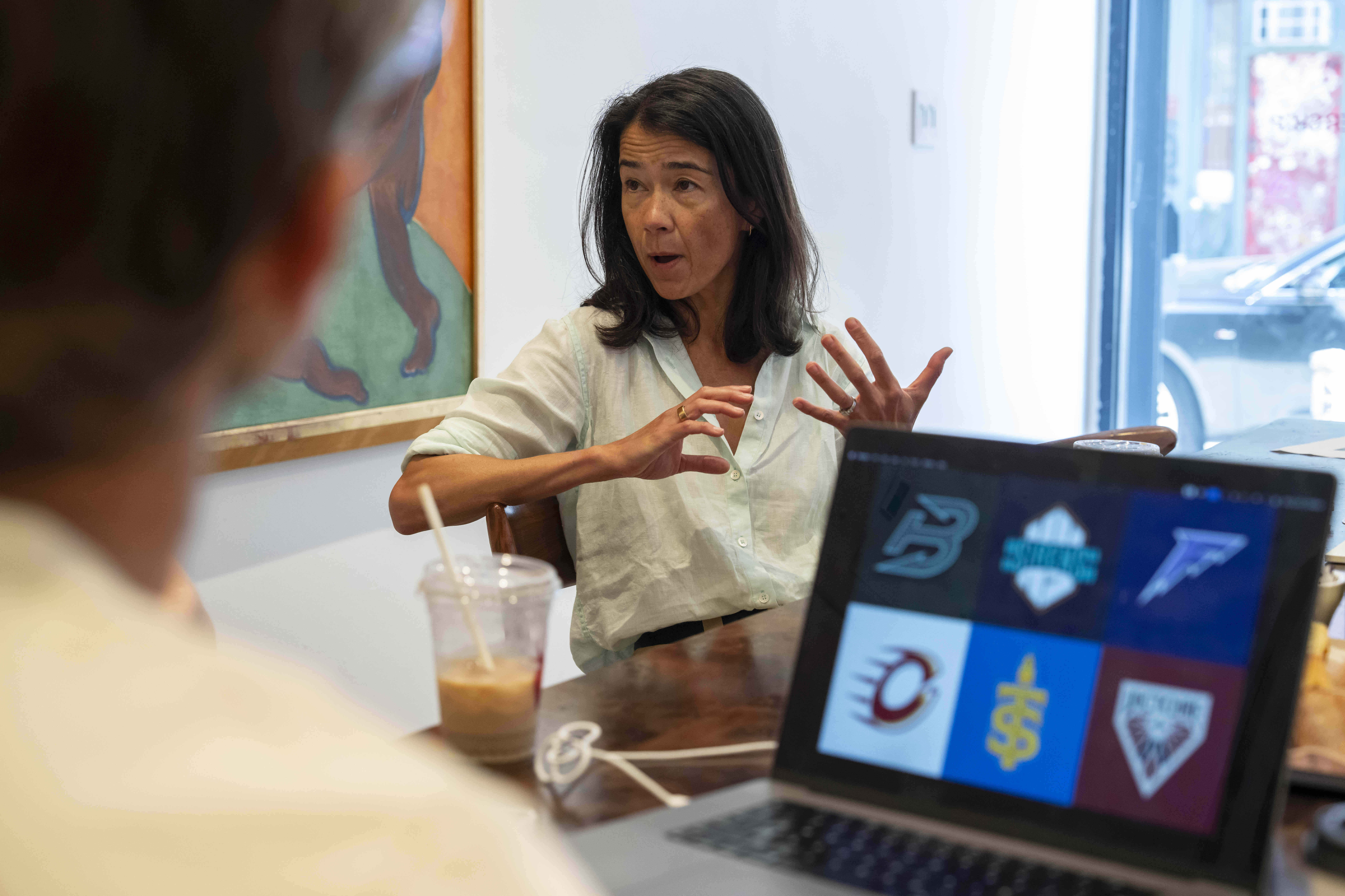 Flower Shop's co-founder and Chief Executive Officer Mary Lou Bunn speaks as sketches of team logos for Professional Women's Hockey League are shown on a computer screen, Thursday, July 30, 2025, in New York. 