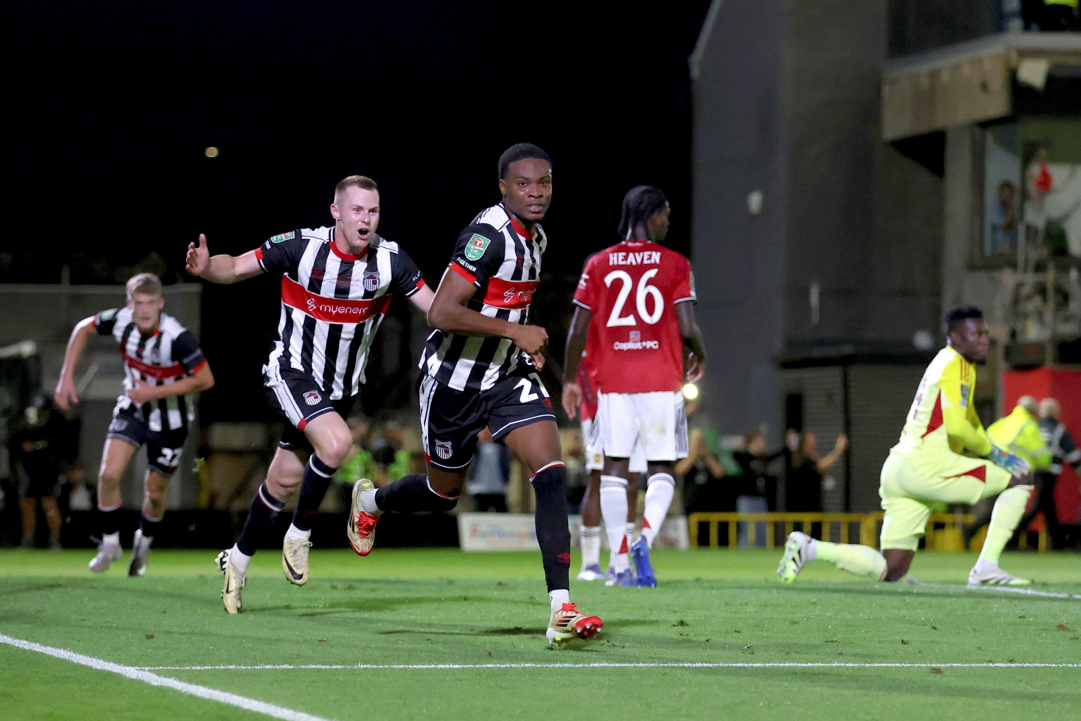Grimsby Town's Tyrell Warren, center, celebrates scoring their side's second goal during an English League Cup second round soccer match against Manchester United, Wednesday, Aug. 27, 2025, at Hill Blundell Park in Grimsby, England.