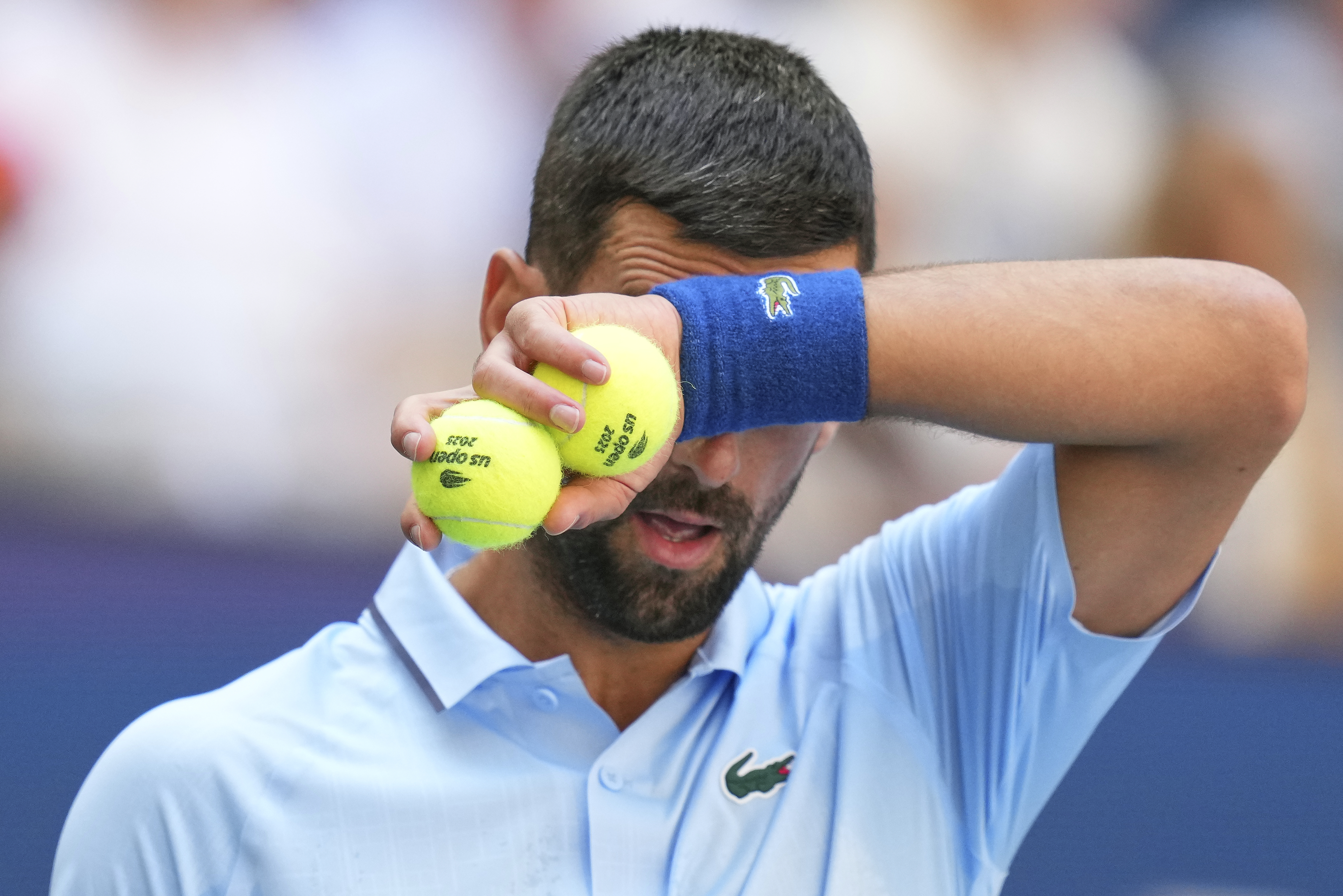 Novak Djokovic, of Serbia, wipes sweat from his face between serves to Zachary Svajda, of the United States, during the second round of the U.S. Open tennis championships, Wednesday, Aug. 27, 2025, in New York. 