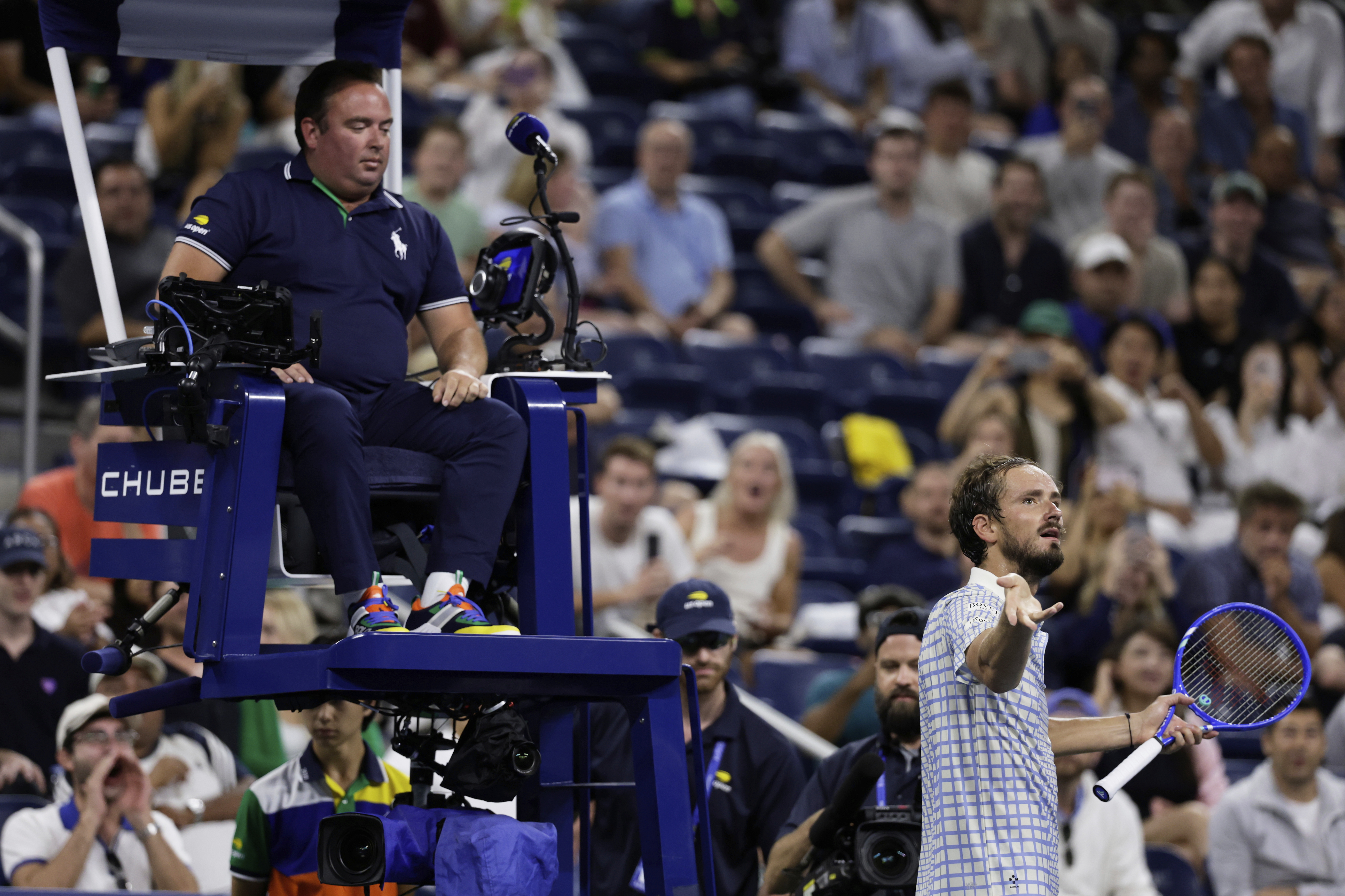 Daniil Medvedev, of Russia, bottom right, reacts next to chair umpire, Greg Allensworth, left, after a photographer ran onto the court during a match against Benjamin Bonzi, of France, in the first-round of the U.S. Open tennis championships, Sunday, Aug. 24, 2025, in New York. 