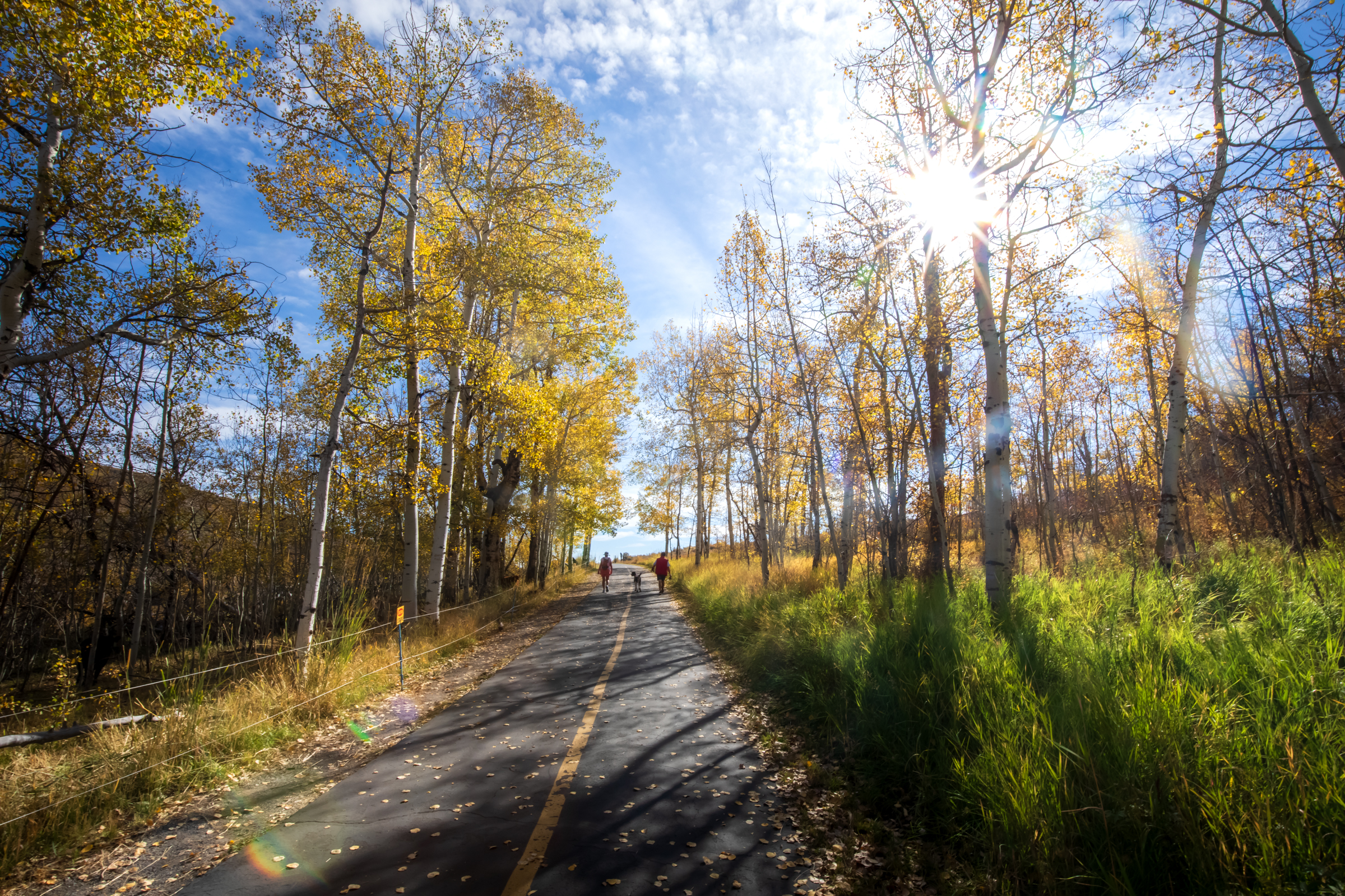 People walk past the fall colors along a pathway in Park City on Oct. 7, 2024.