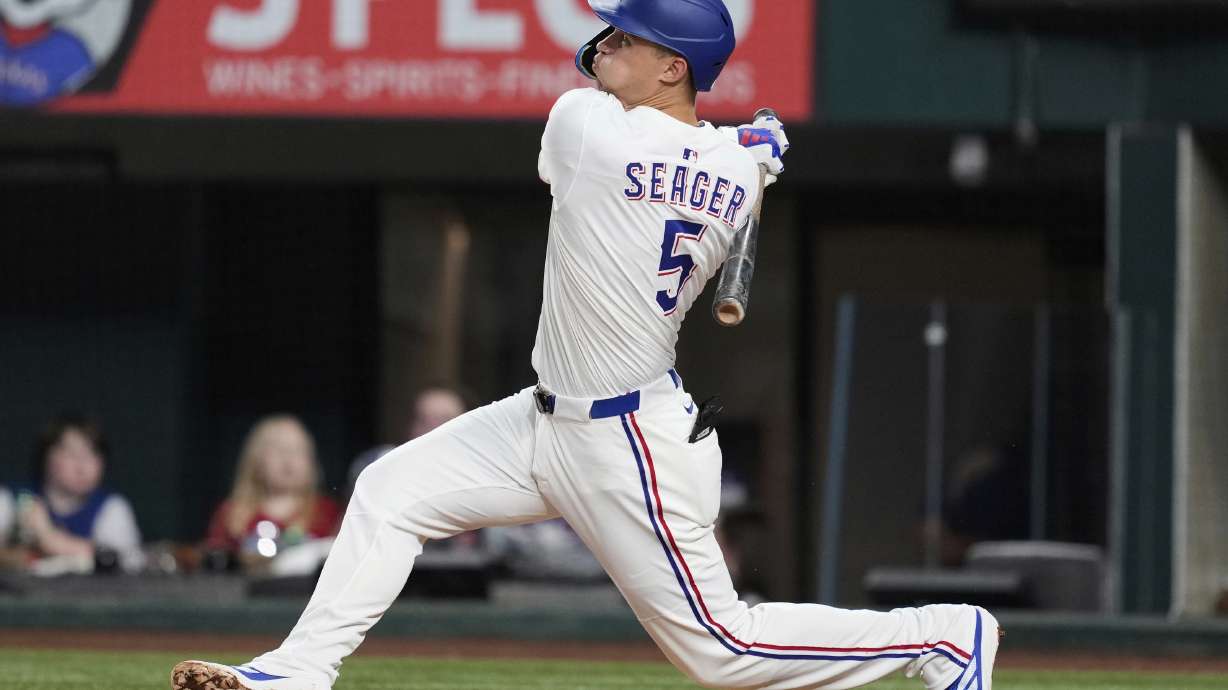 Texas Rangers shortstop Corey Seager follows through on a solo home run swing in the fourth inning of a baseball game against the Los Angeles Angels, Wednesday, Aug. 27, 2025, in Arlington, Texas.